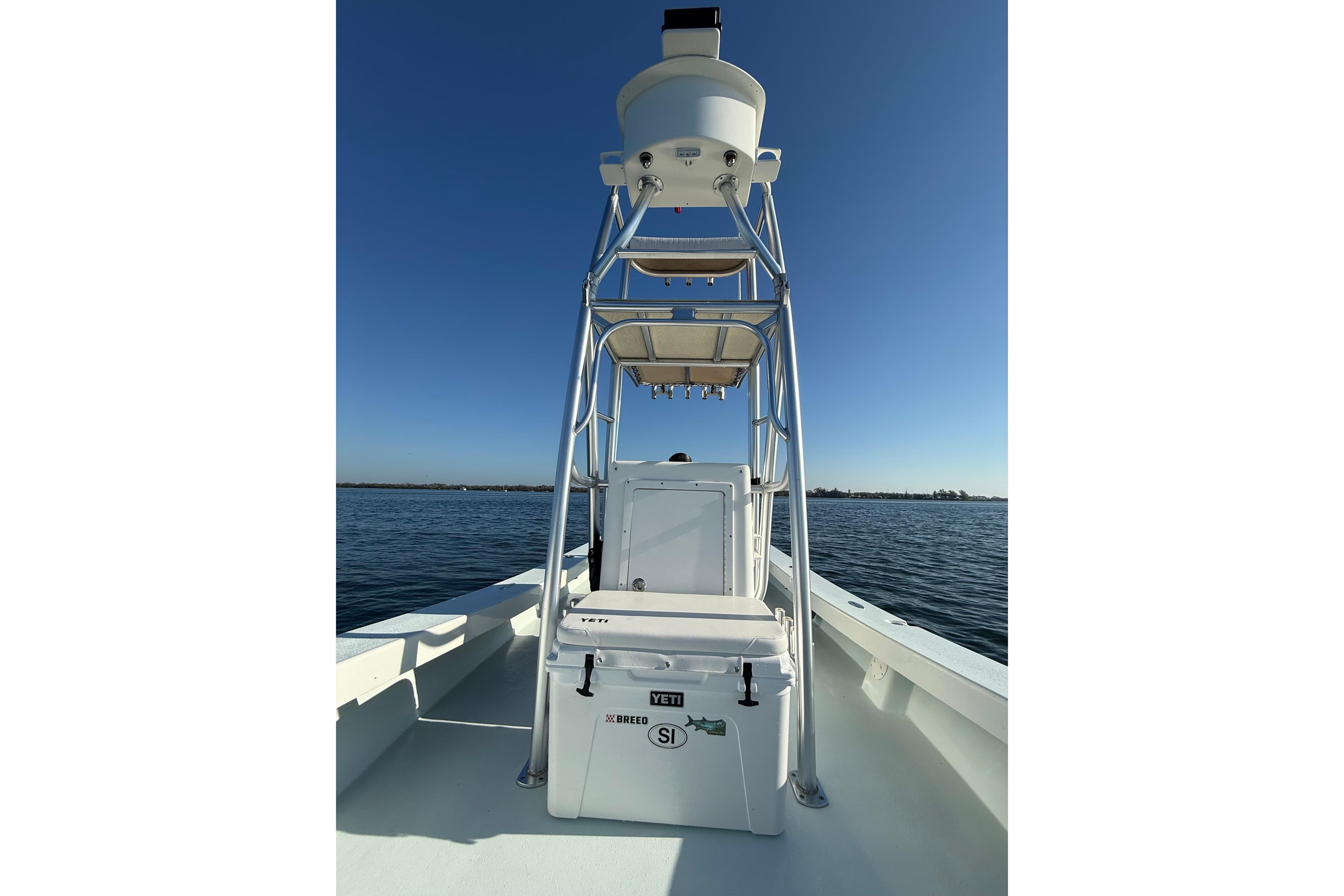 1987 Privateer 22 Roamer boat on calm water under clear blue sky.