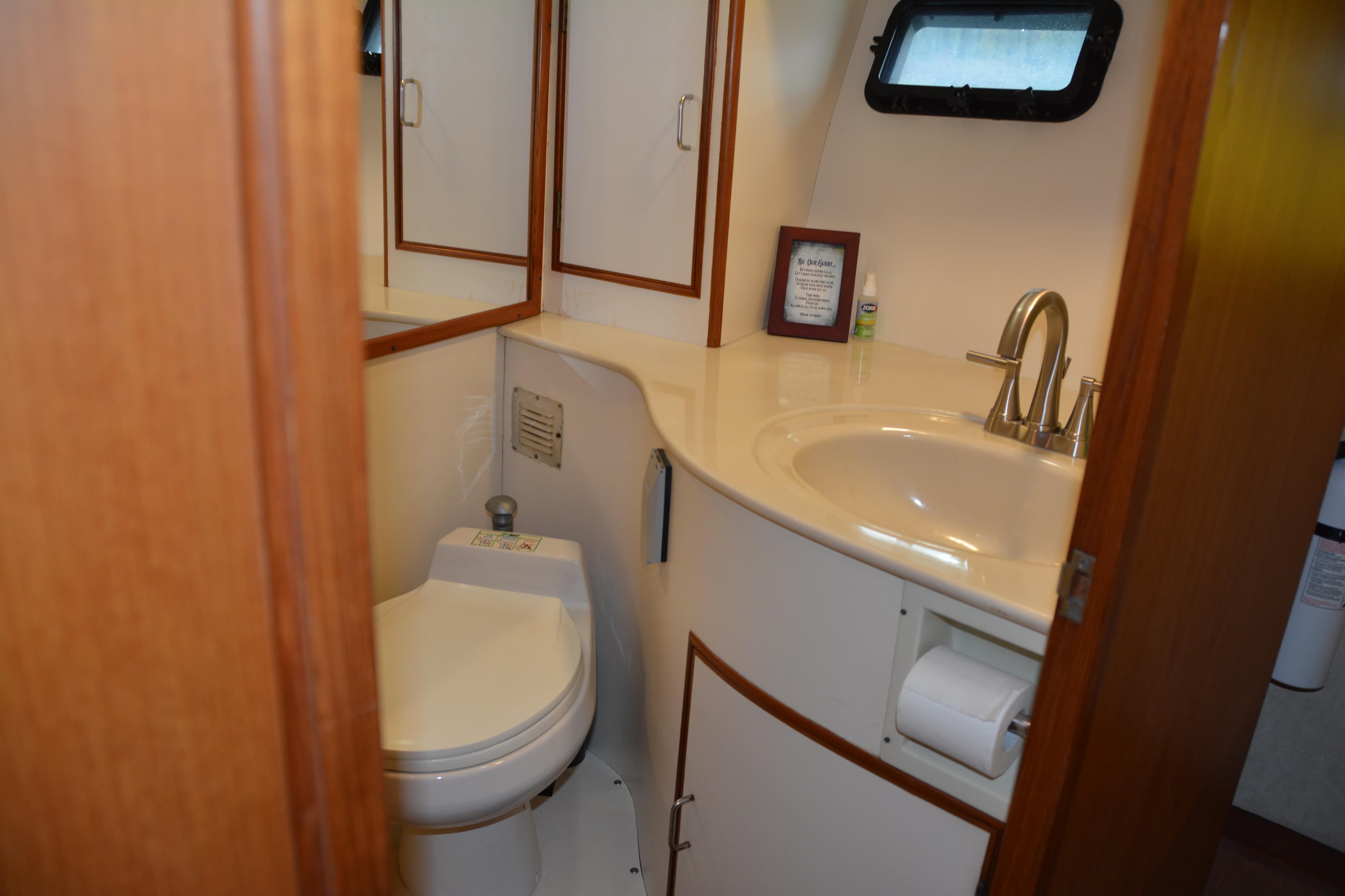 1988 Camargue 48 Cockpit Motor Yacht bathroom with sink, toilet, and mirror.