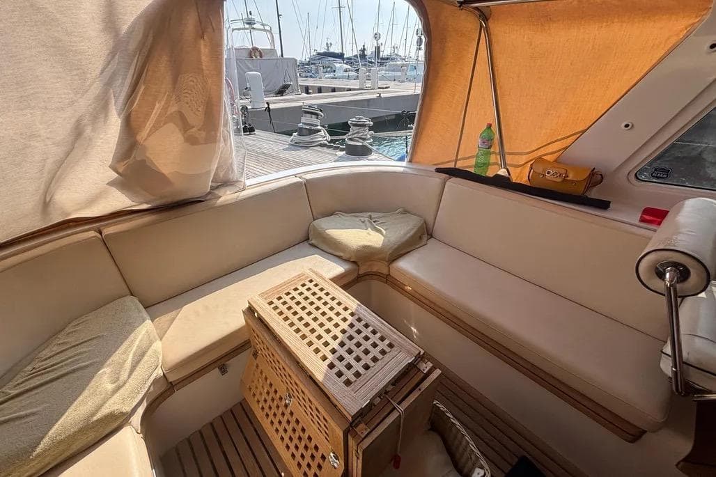 Luxurious 1988 Jongert 2000s yacht interior with beige seating and wooden accents at a marina.