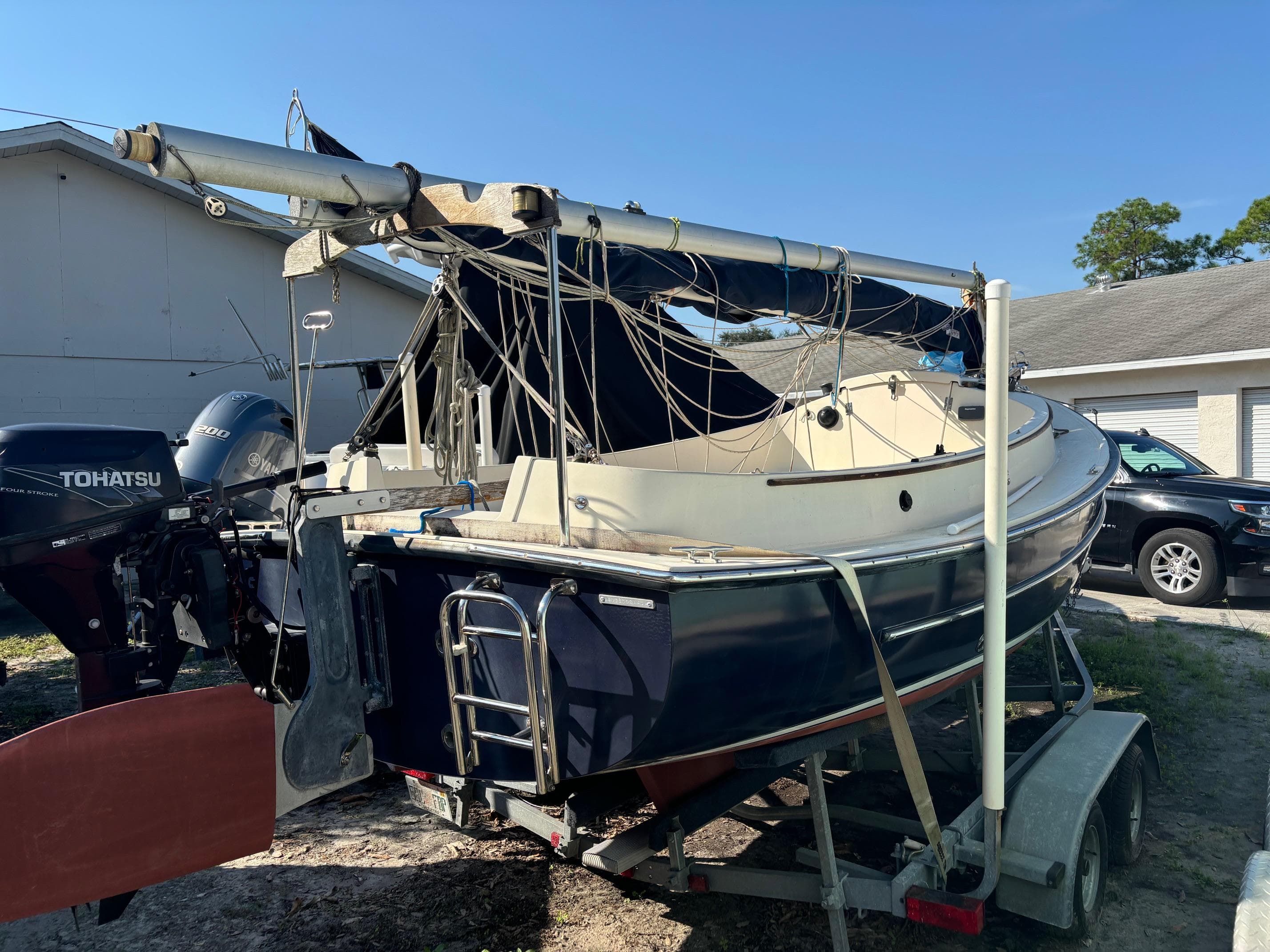 2014 Com-Pac Horizon Day Cat sailboat on trailer with Tohatsu outboard motor.