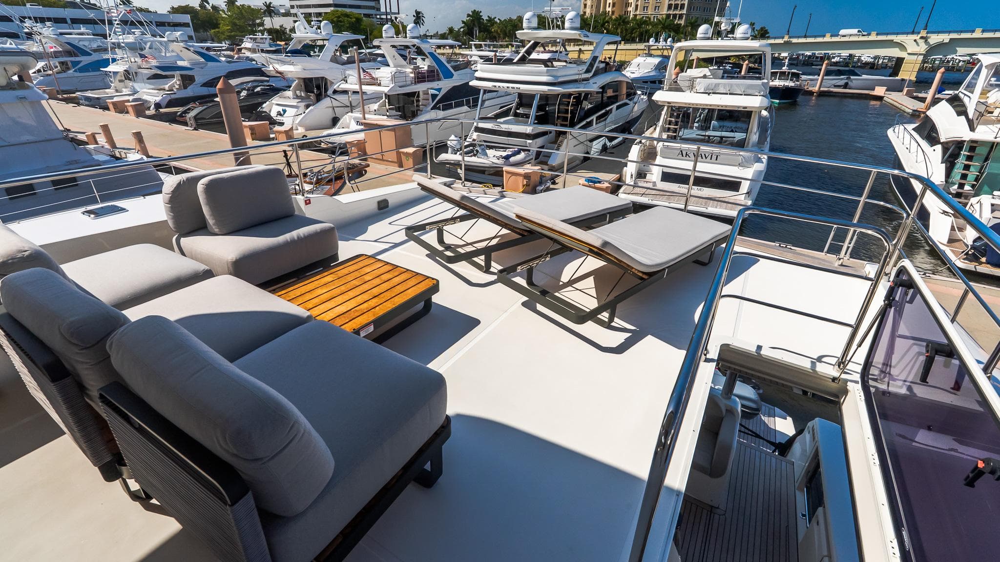 Luxurious 2024 Absolute 68 NAVETTA yacht deck with lounge chairs and marina view.