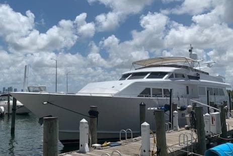 Luxury 1990 Broward Raised Pilothouse MY yacht docked under a cloudy sky.