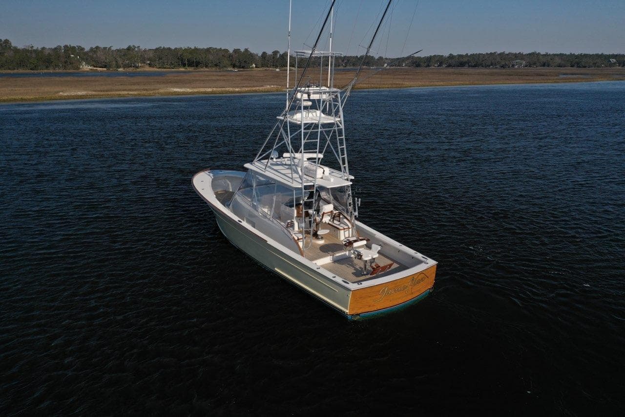 2007 Gamefisherman 42 Walkaround boat on calm water, featuring a sleek design and fishing tower.
