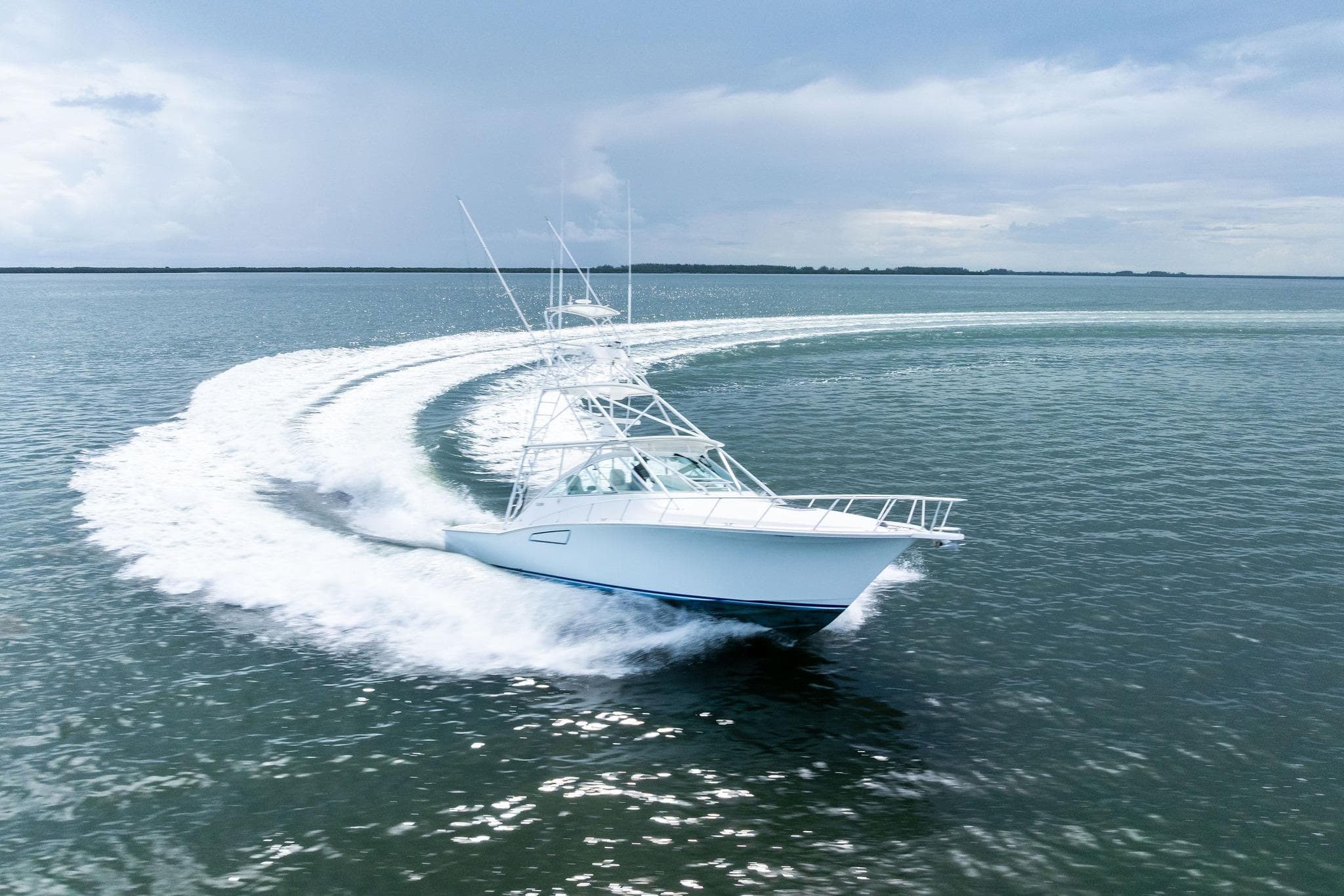 2004 Cabo 40 Hardtop Express yacht making a sharp turn on open water.