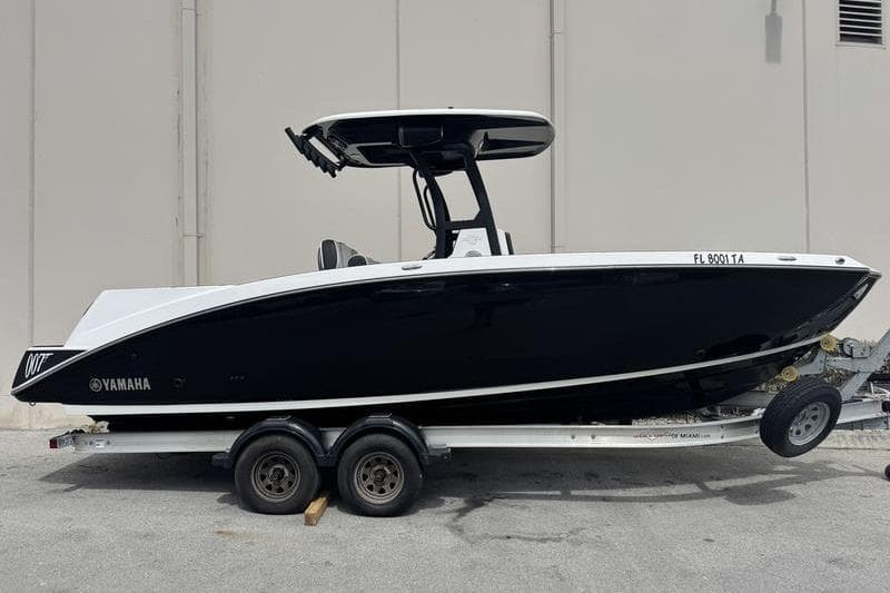 2021 Yamaha Boats 255 FSH Sport E on trailer, sleek black design.