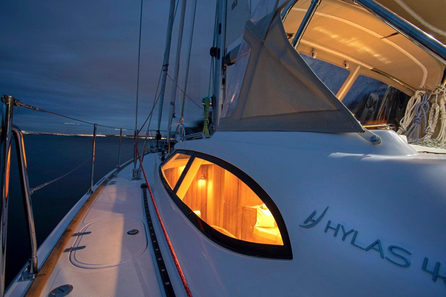 Manufacturer Provided Image: 2025 Hylas H48 yacht at dusk, illuminated cabin, sleek design.