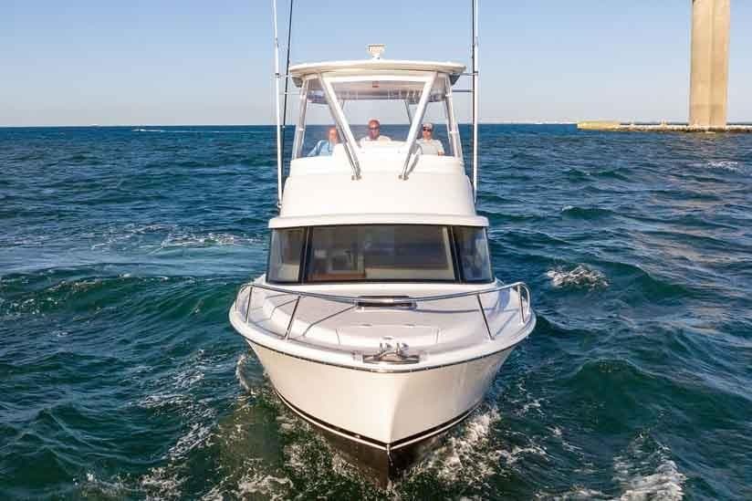Manufacturer Provided Image: 2026 Bertram 35 Flybridge cruising on open water near a pier.