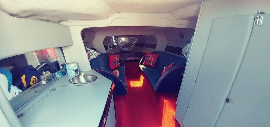 Interior of a 1988 Fountain 12 Meter boat with seating and kitchenette.
