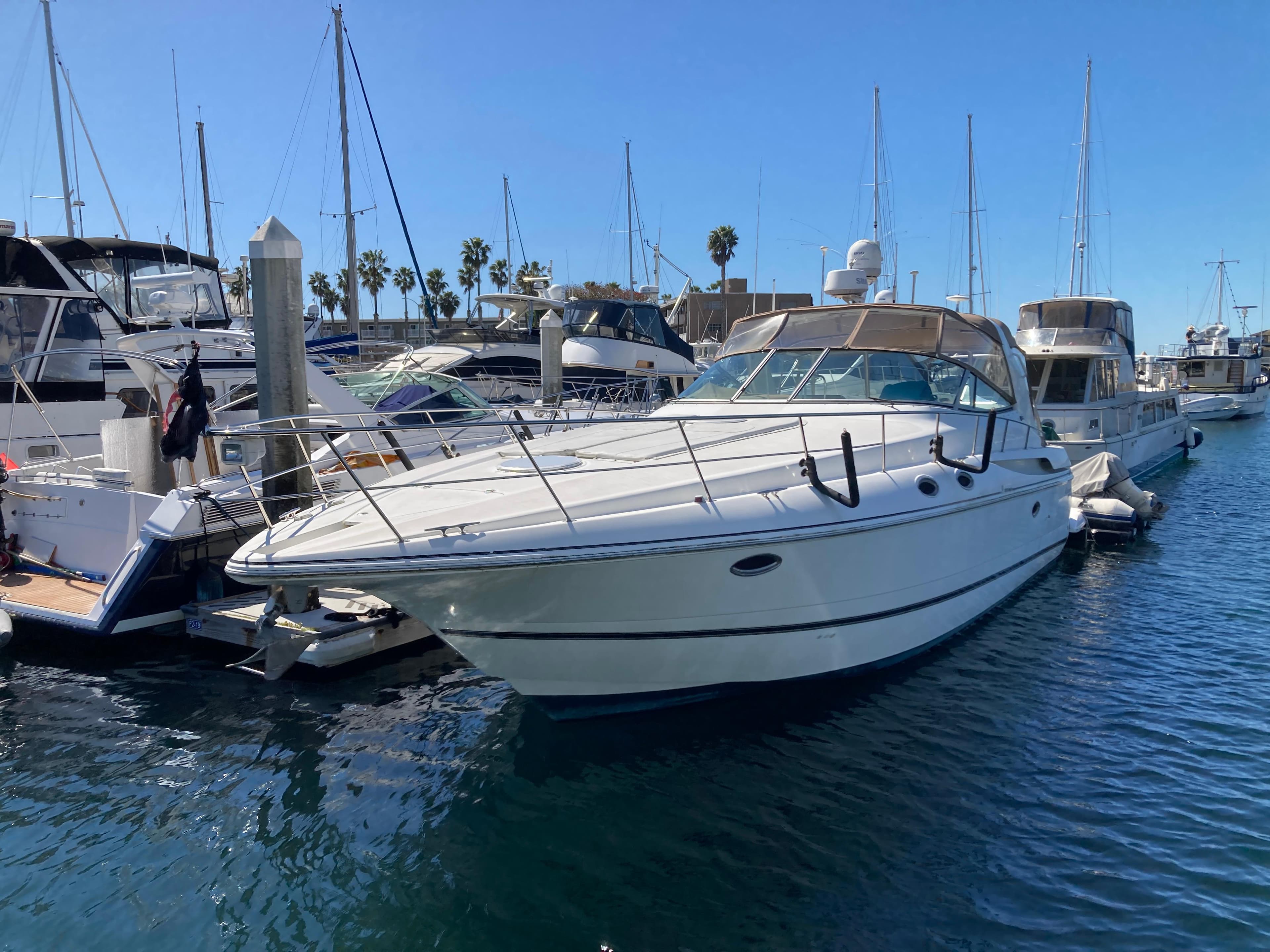 1999 Cruisers Yachts 3870 Esprit docked in a marina, surrounded by other boats.
