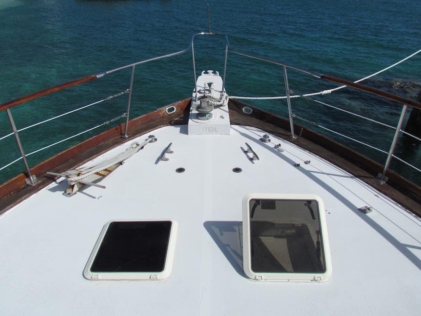 1972 Hargrave 67 Motor Yacht deck with hatches, overlooking clear blue water.