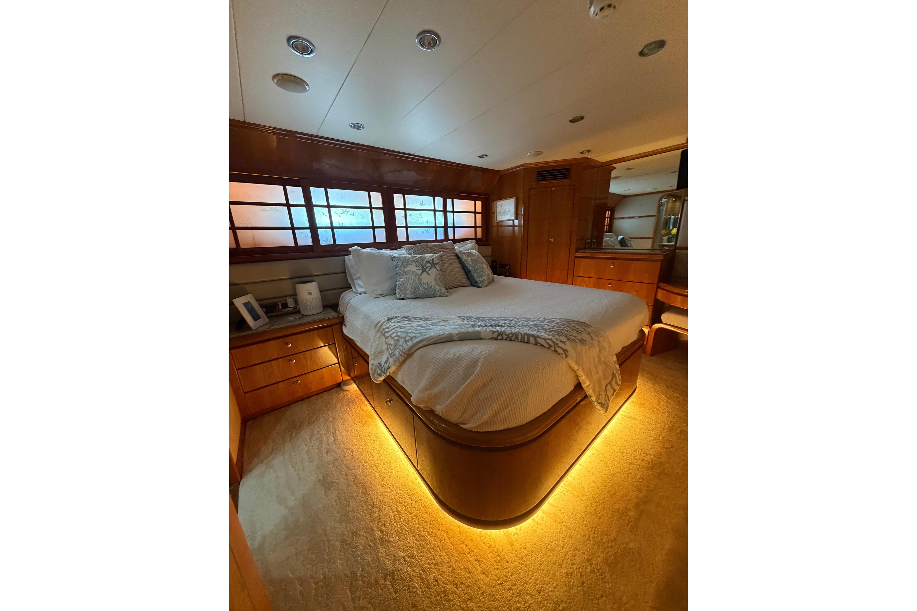 Luxurious bedroom interior of 2001 Hargrave 94 yacht with ambient lighting and elegant wood finishes.