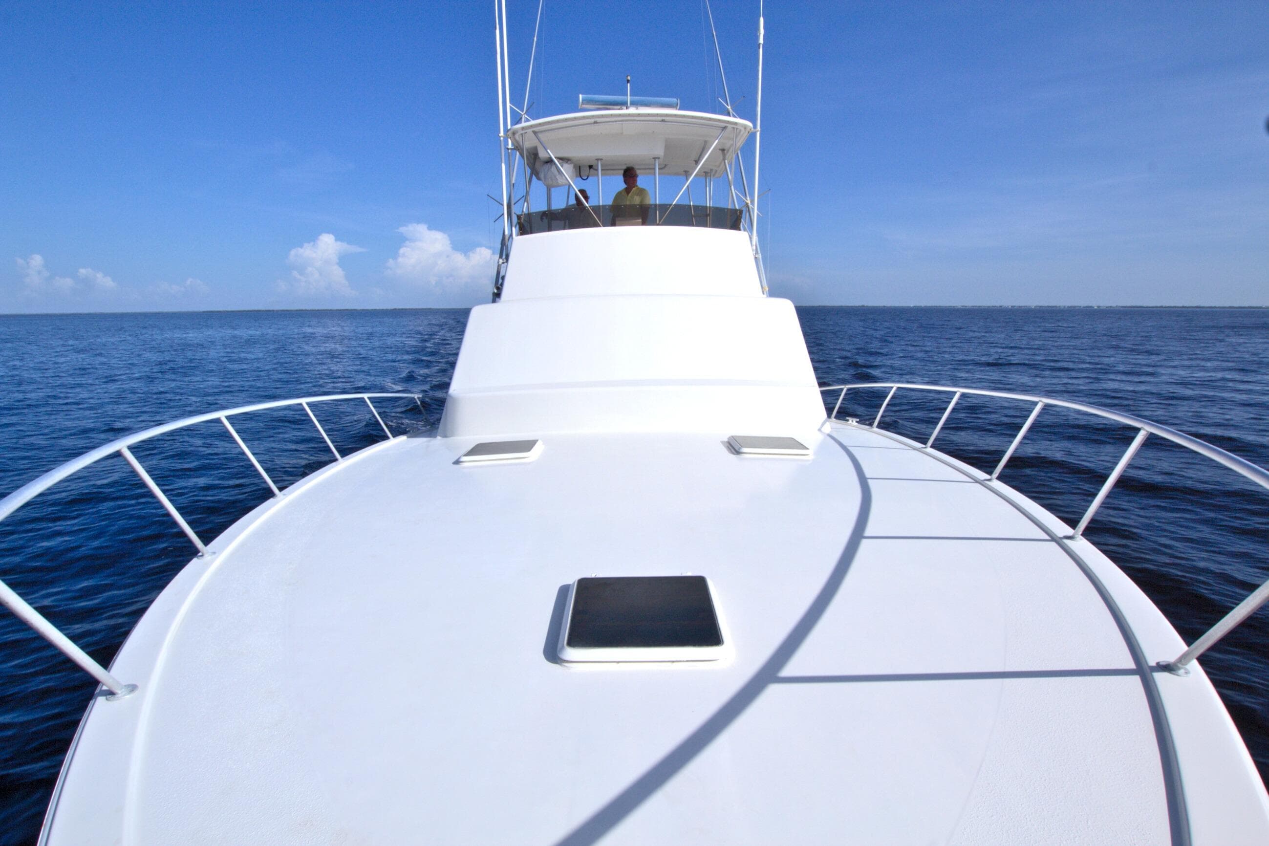 1990 Post 44 Sport Fisherman yacht cruising on open sea under clear blue sky.