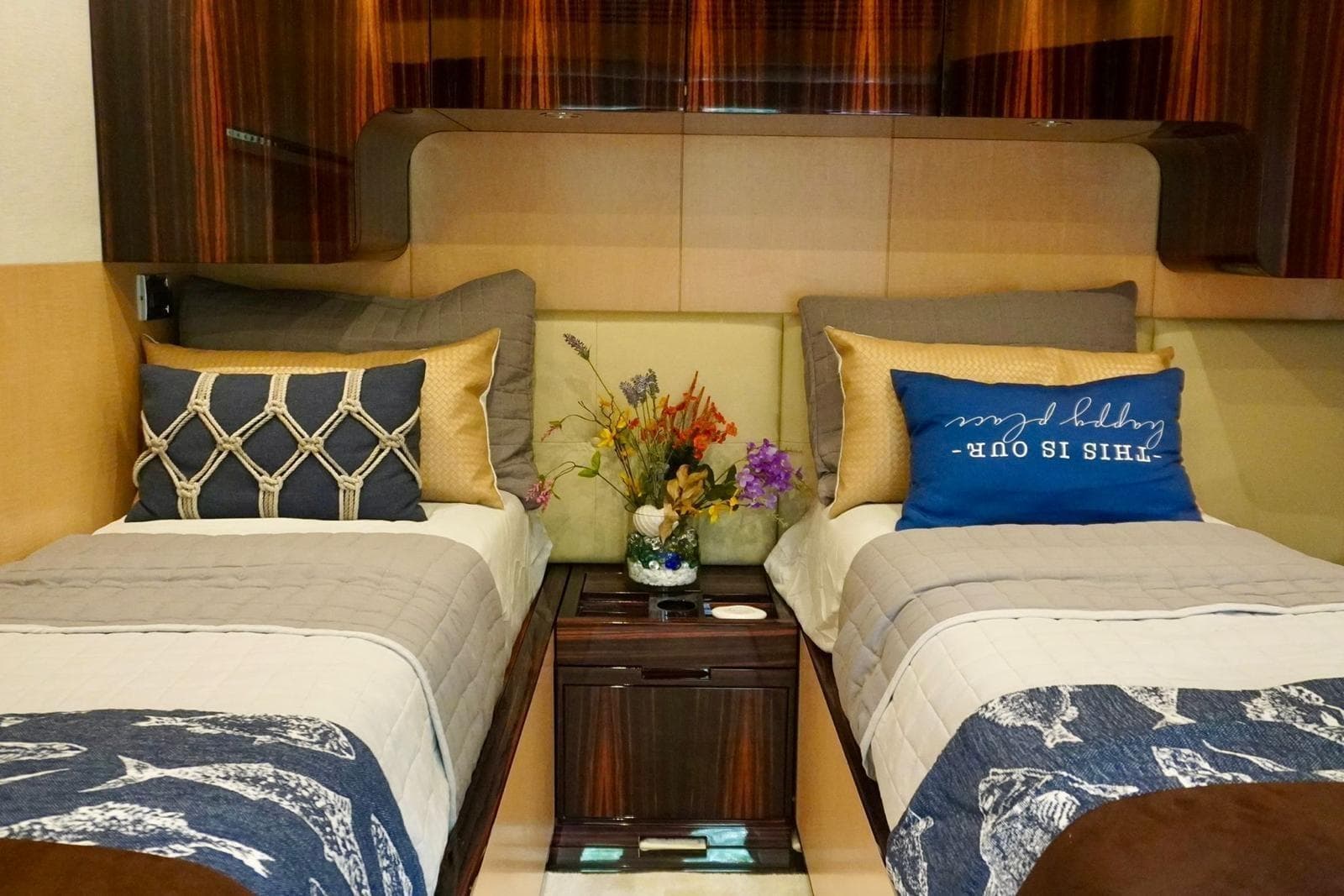 Luxurious twin bedroom on 2015 Azimut 84 yacht with elegant decor and floral arrangement.