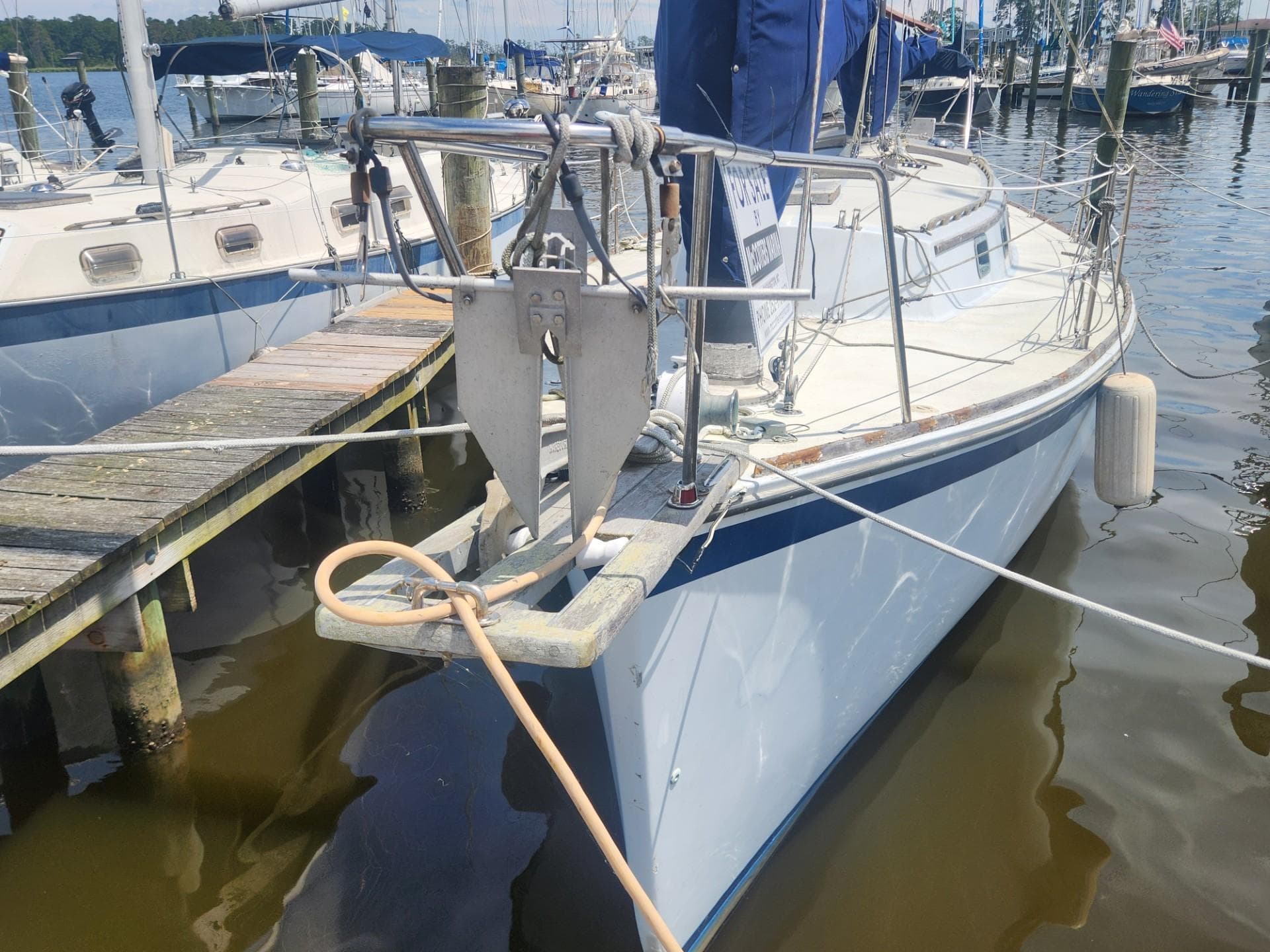 1985 Herreshoff 38 Cat Ketch sailboat docked at a marina.