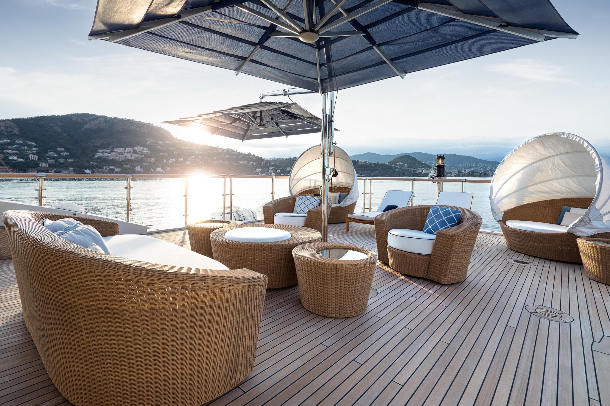 Luxurious deck of 2011 Benetti 60 yacht with wicker furniture and ocean view.