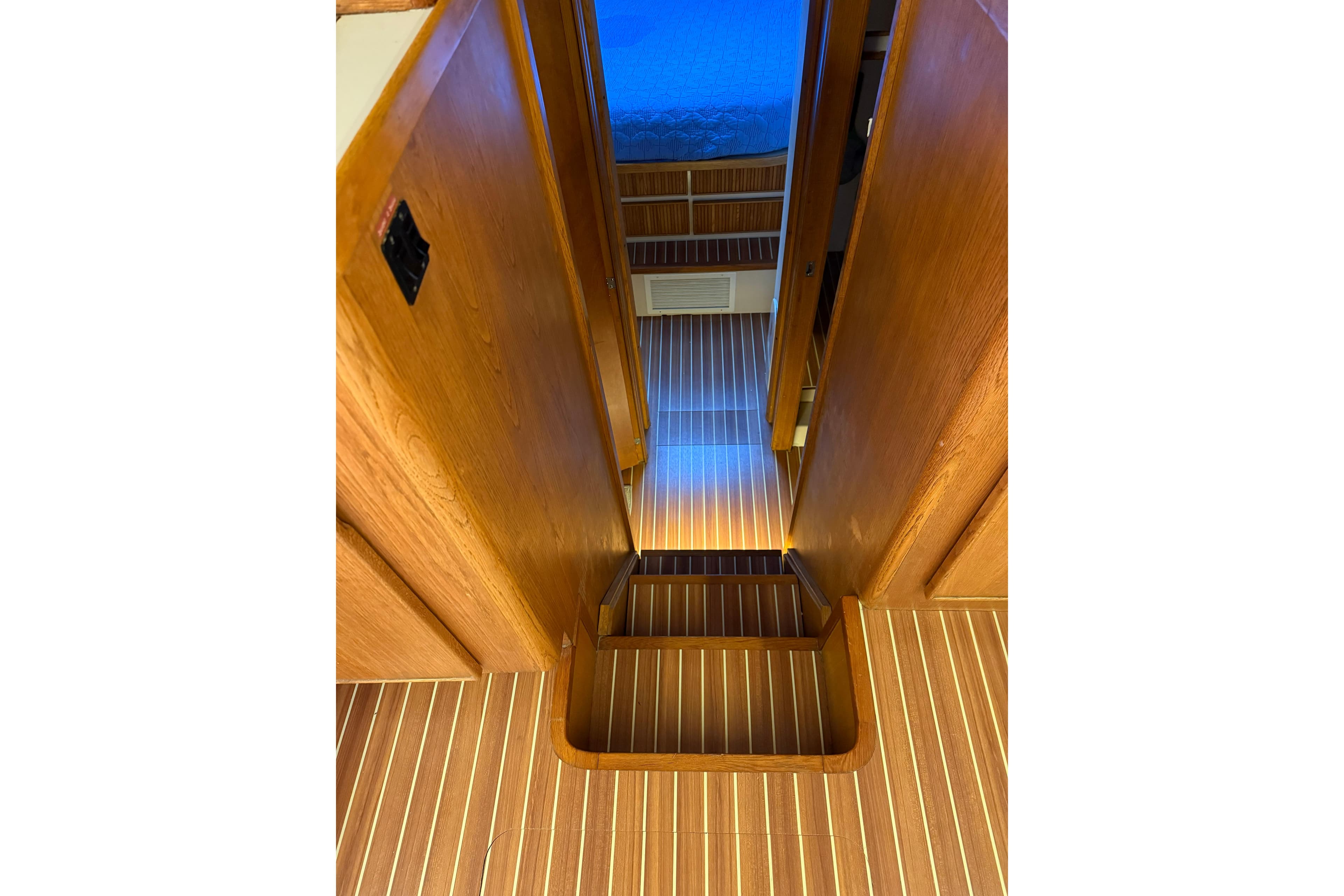 Interior of 1987 Bertram 37 Convertible yacht with wooden flooring and stairs.