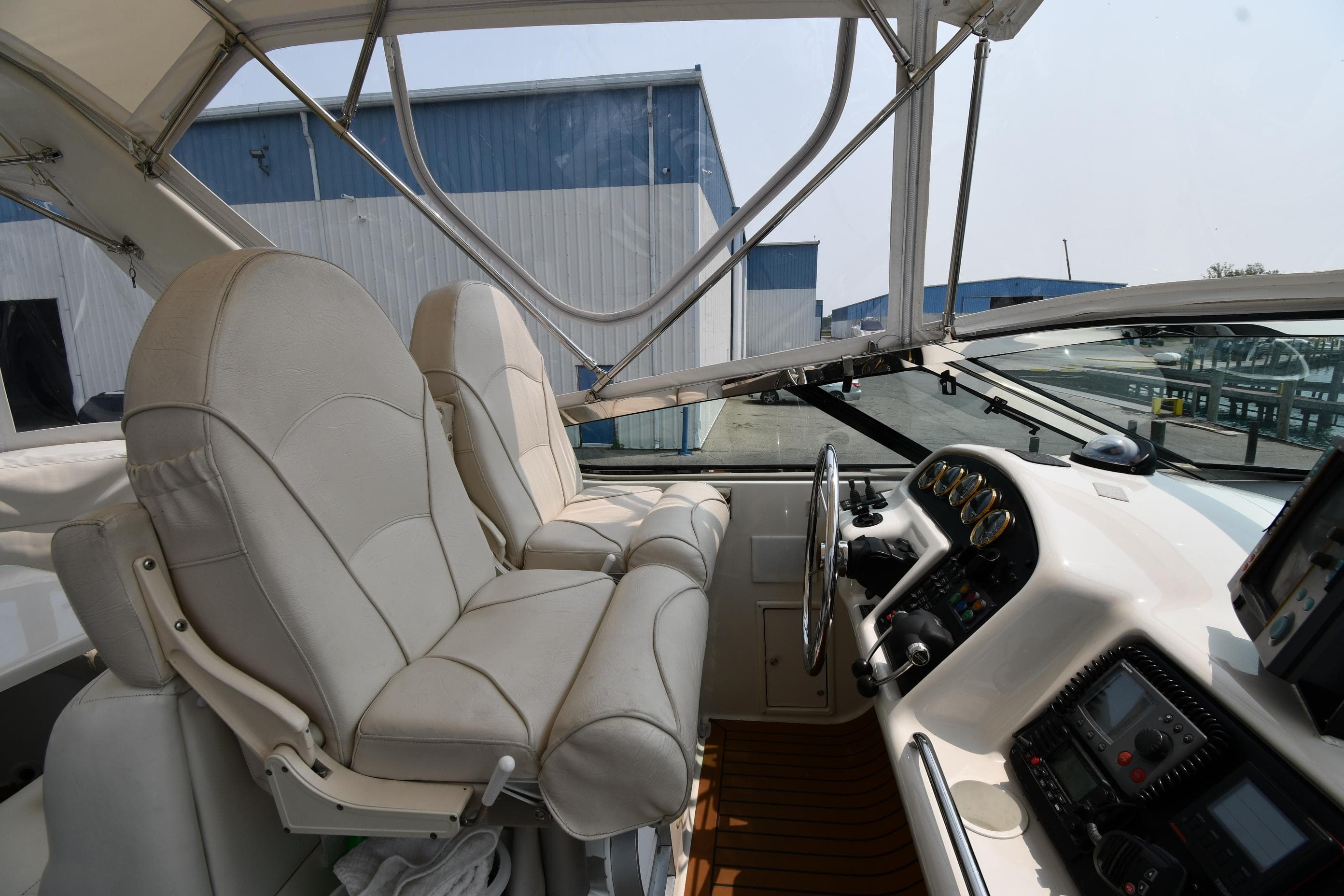 1998 Carver 530 Voyager Pilothouse interior with helm, leather seats, and navigation equipment.