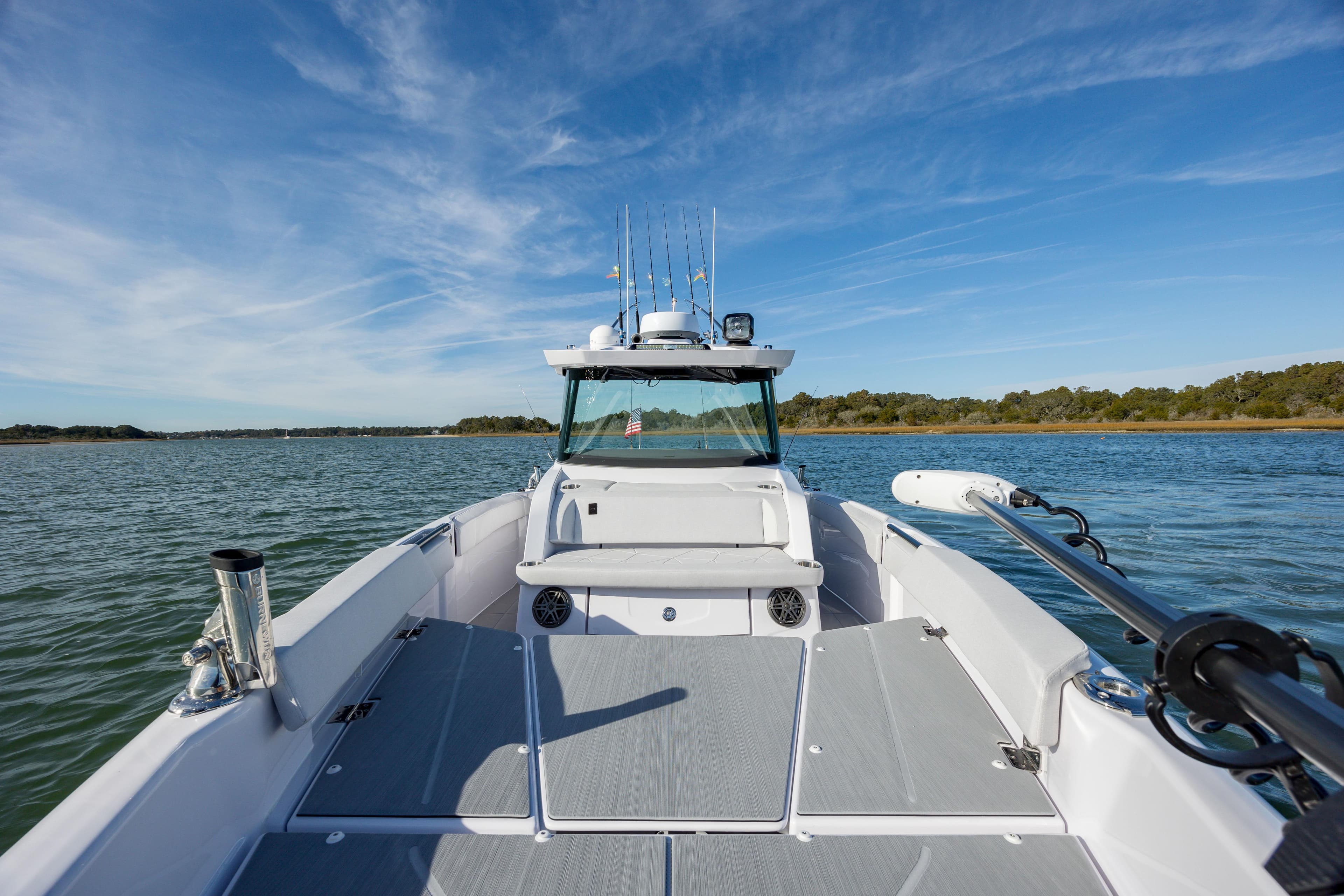 2025 Axopar 29 CCX boat on calm water under clear blue sky.