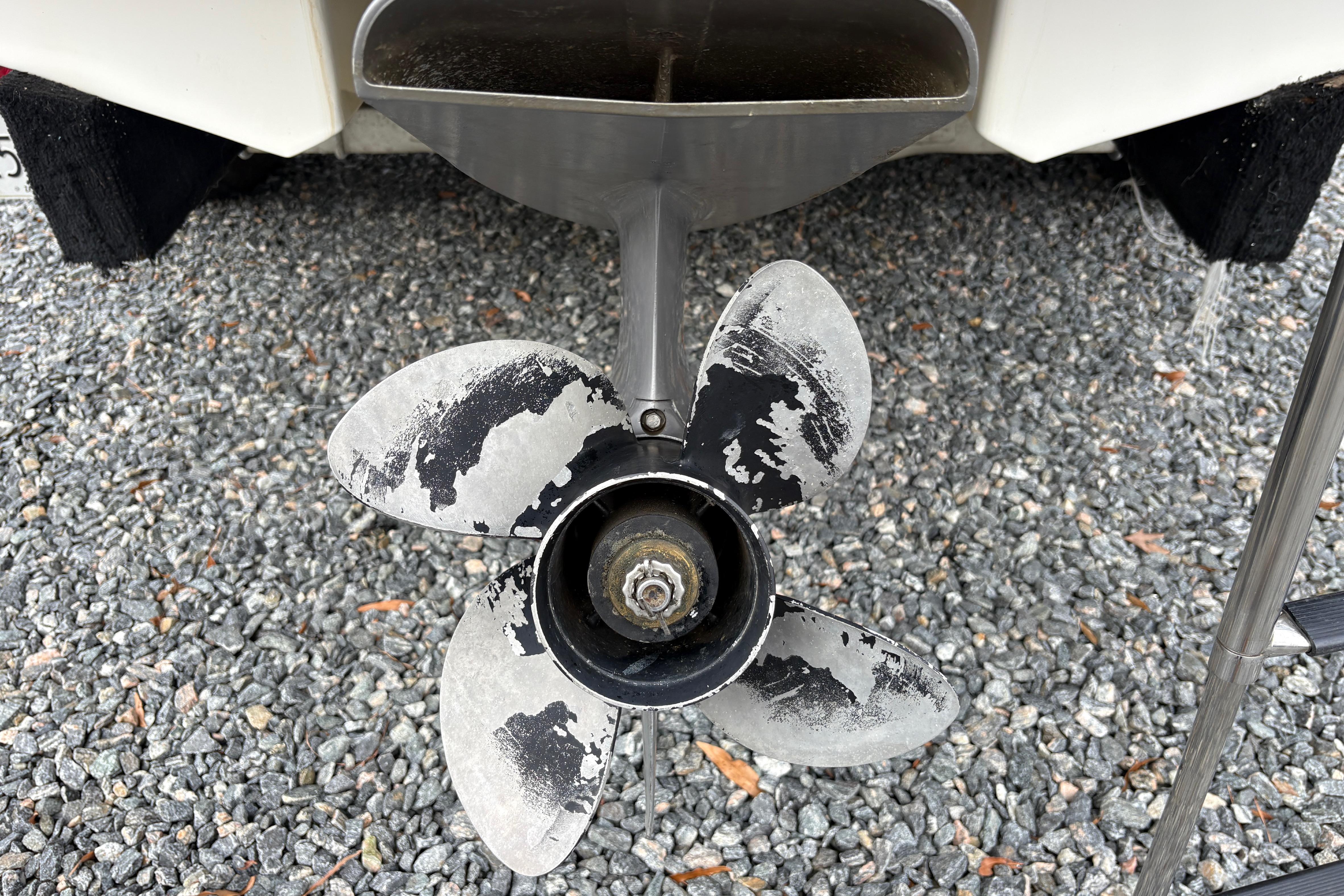 Worn propeller of a 2007 Chaparral 190 SSi boat on gravel surface.