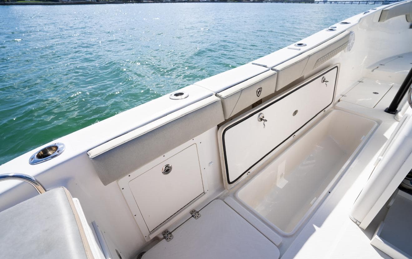 2019 Century 3200 Center Console boat interior with storage compartments, on calm water.