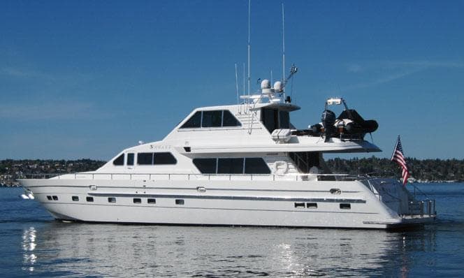 Luxury 2001 Horizon Skylounge yacht on calm water with clear blue sky.