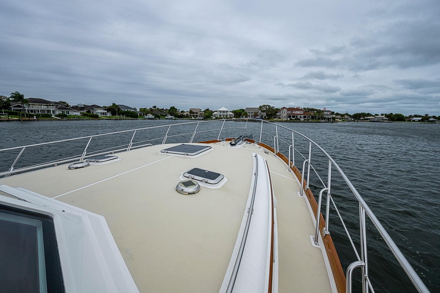 Bow view of 2014 Grand Banks 46 Eastbay SX yacht on a calm waterway.