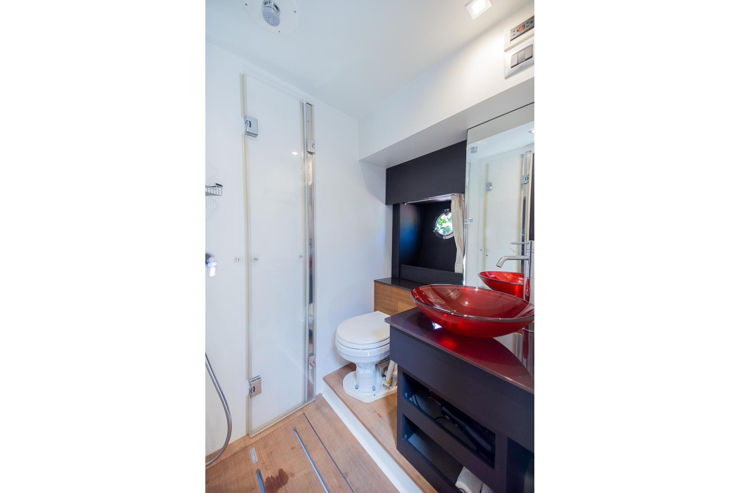Luxurious bathroom in 2014 Cranchi M 44 HT yacht with modern fixtures and red glass sink.
