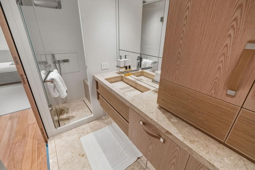 Luxurious bathroom in 2023 Sanlorenzo SD118 yacht with modern fixtures and elegant wood cabinetry.
