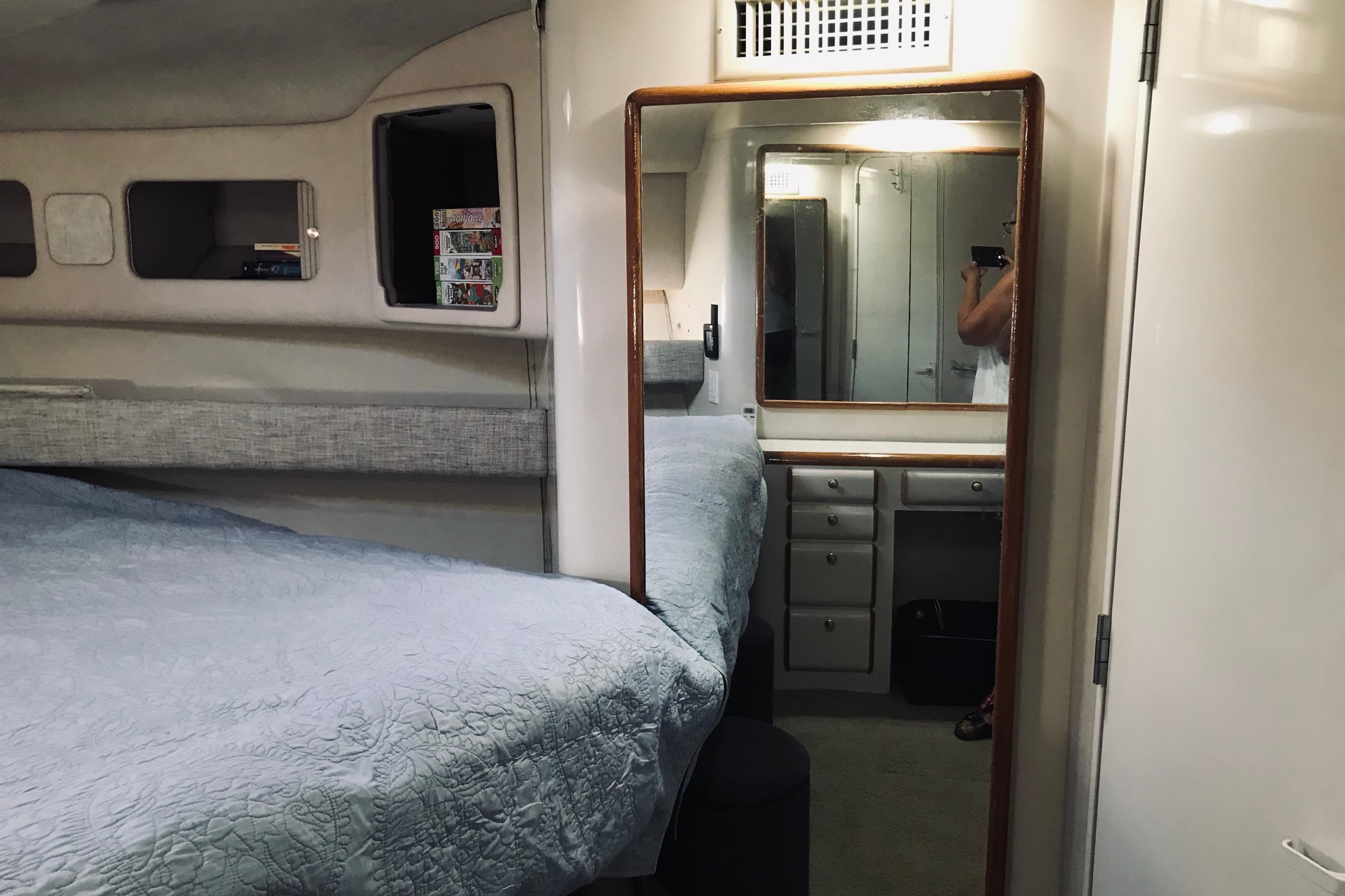 Interior cabin of a 1995 Sea Ray 550 Sedan Bridge with bed and mirror.
