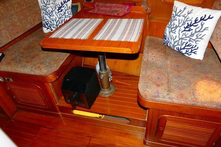 1982 Ta Shing Mason 63 yacht interior with wooden dining area and decorative cushions.