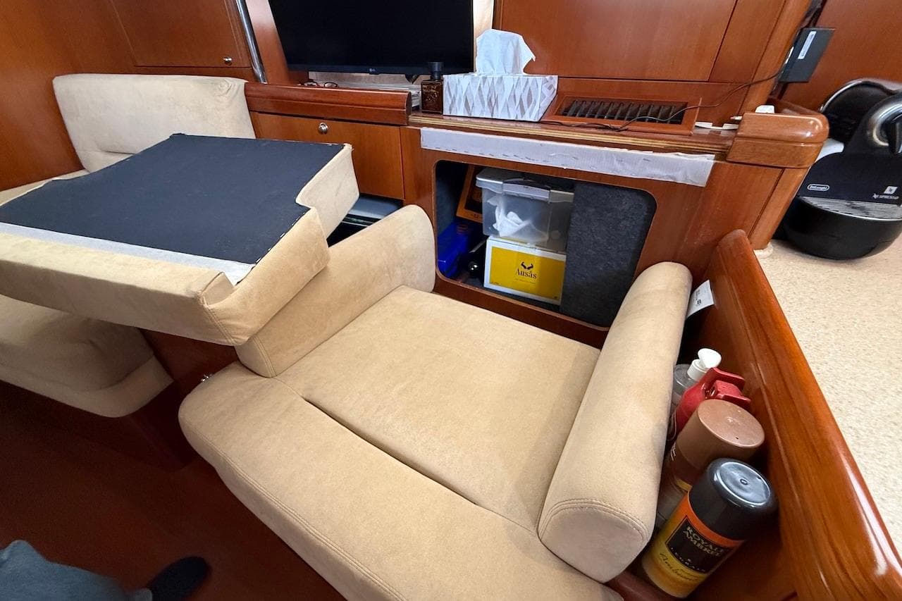 Cozy interior of 2002 Moody 47 yacht with beige seating and wooden accents.