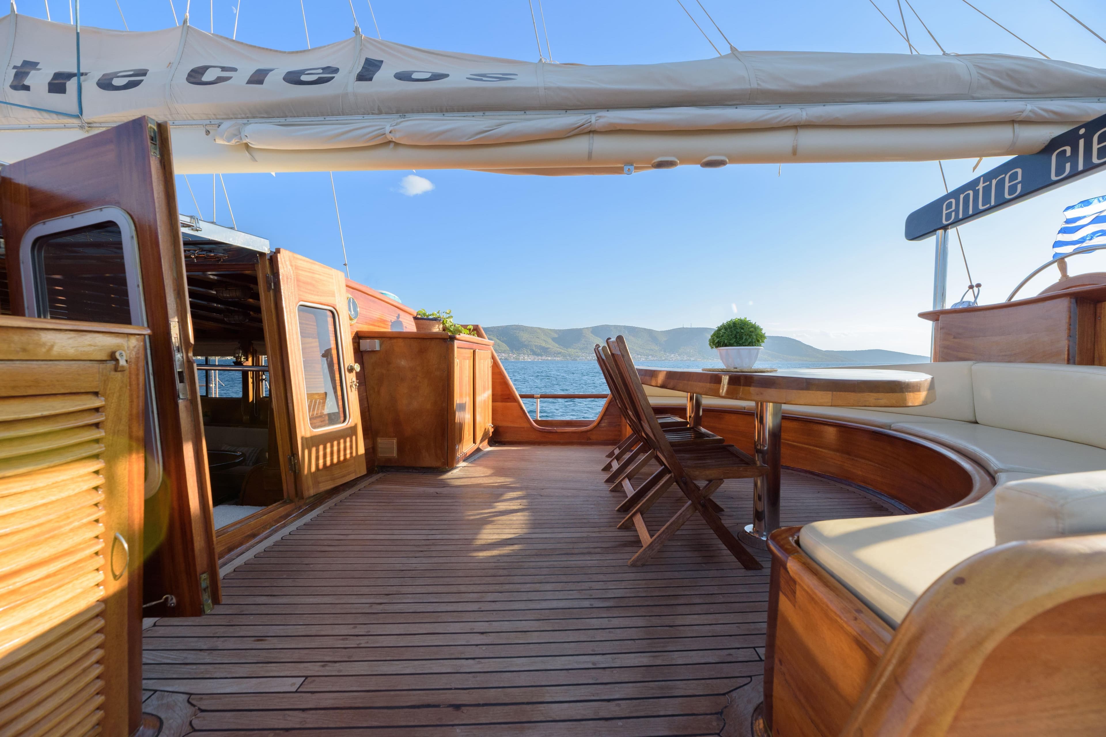 Luxurious 2004 Su Marine Gulet deck with wooden seating, ocean view, and clear skies.