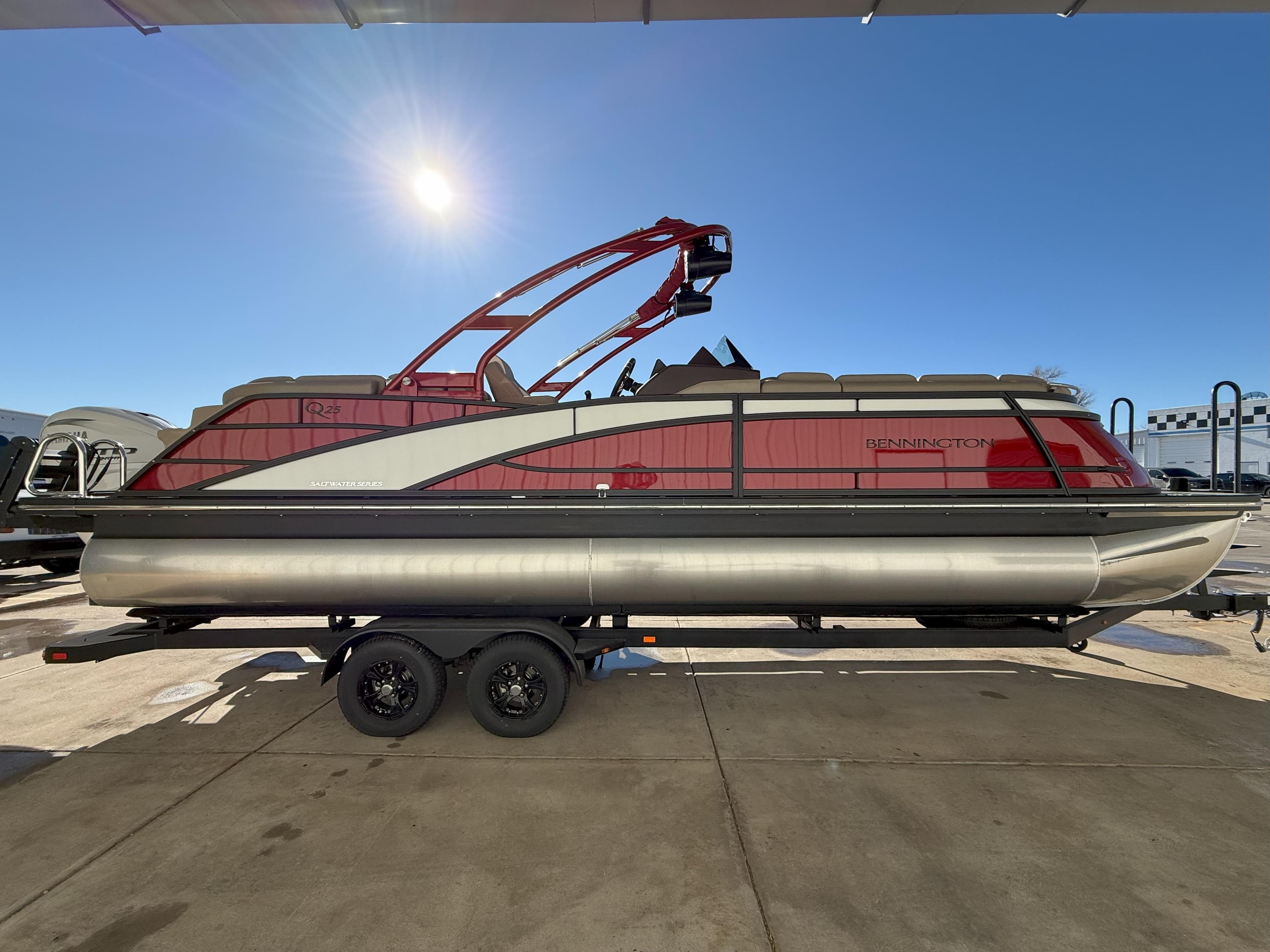 2025 Bennington 25QXFB pontoon boat on trailer under clear blue sky.