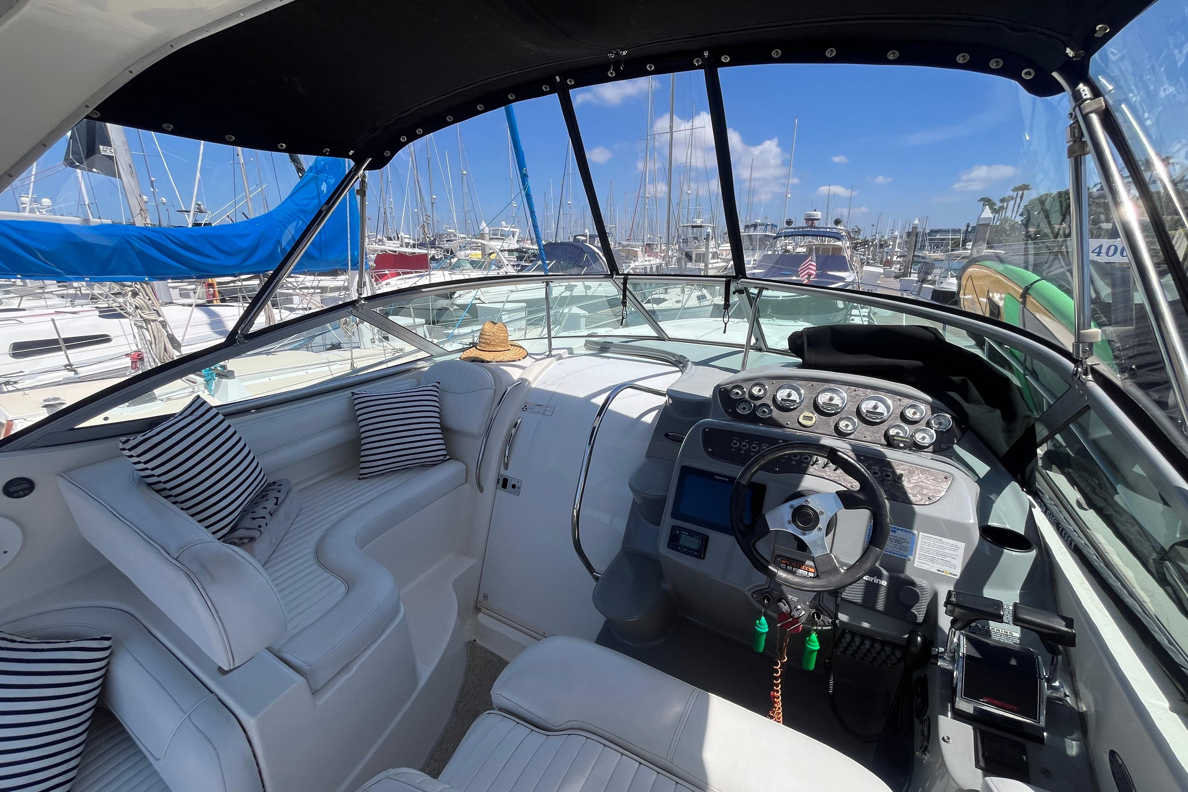 Interior of 2007 Maxum 3100 SE boat with helm, seating, and marina view.