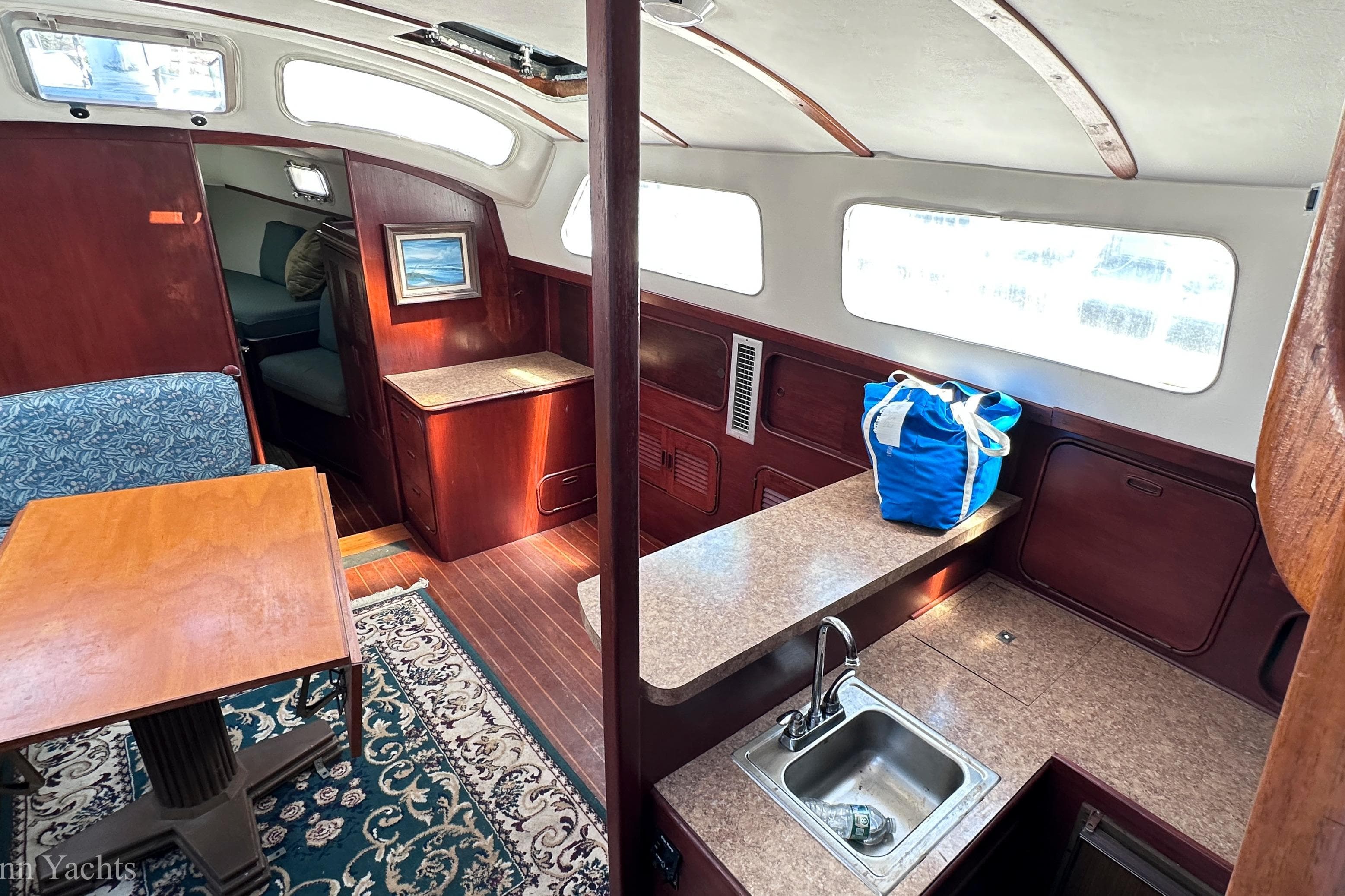 Interior of a 1980 Irwin 46 yacht with wood finishes and a compact kitchen area.