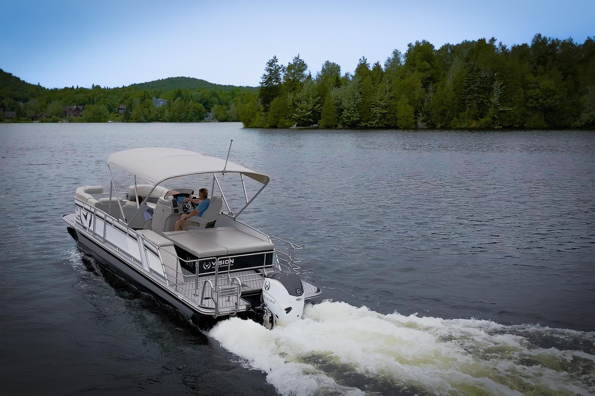 2025 Vision Marine Technologies V24 boat cruising on a serene lake with lush green surroundings.