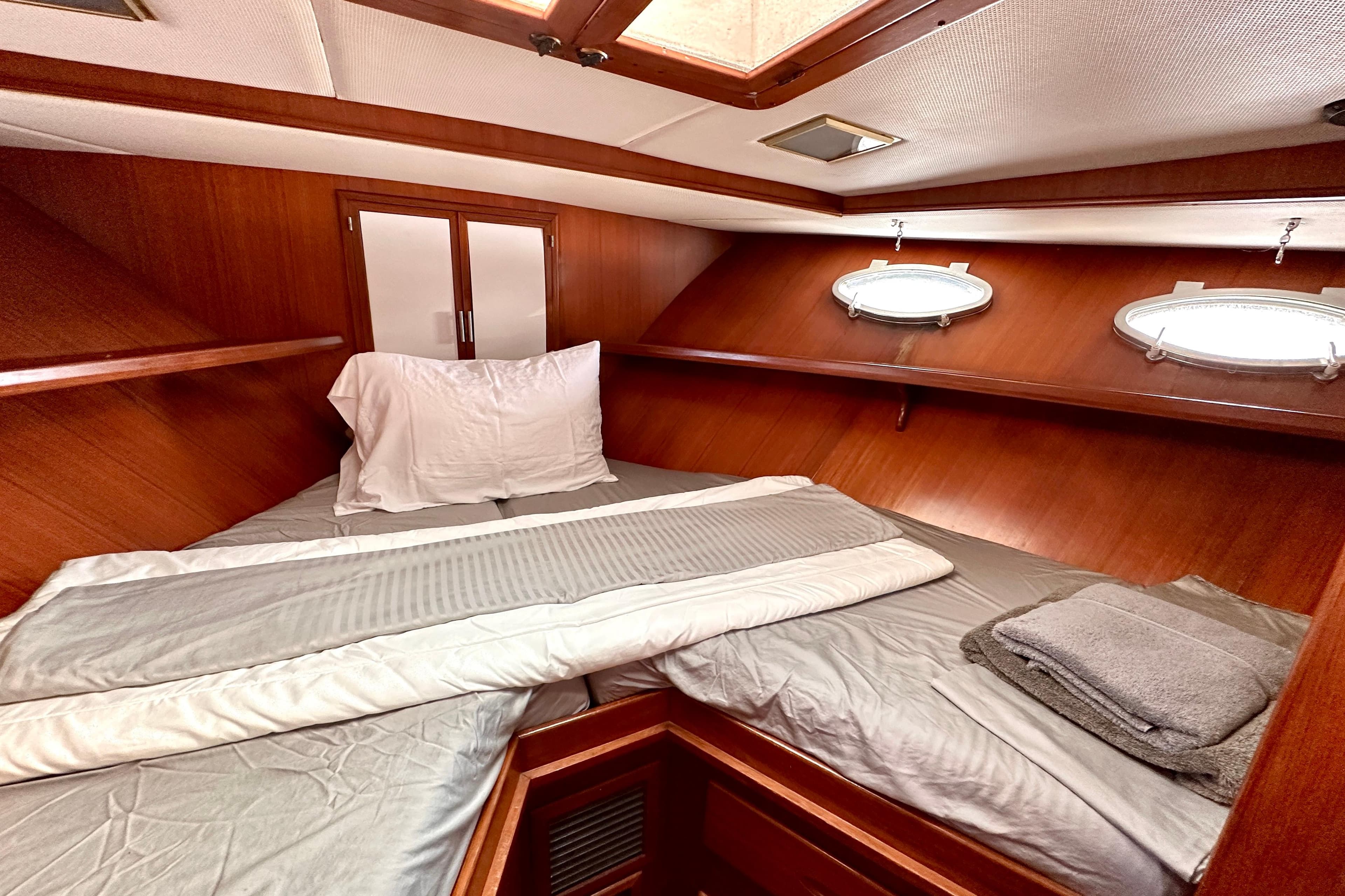 Cozy cabin interior of 1987 Marine Trader 47 Tradewinds yacht with wood paneling and bedding.