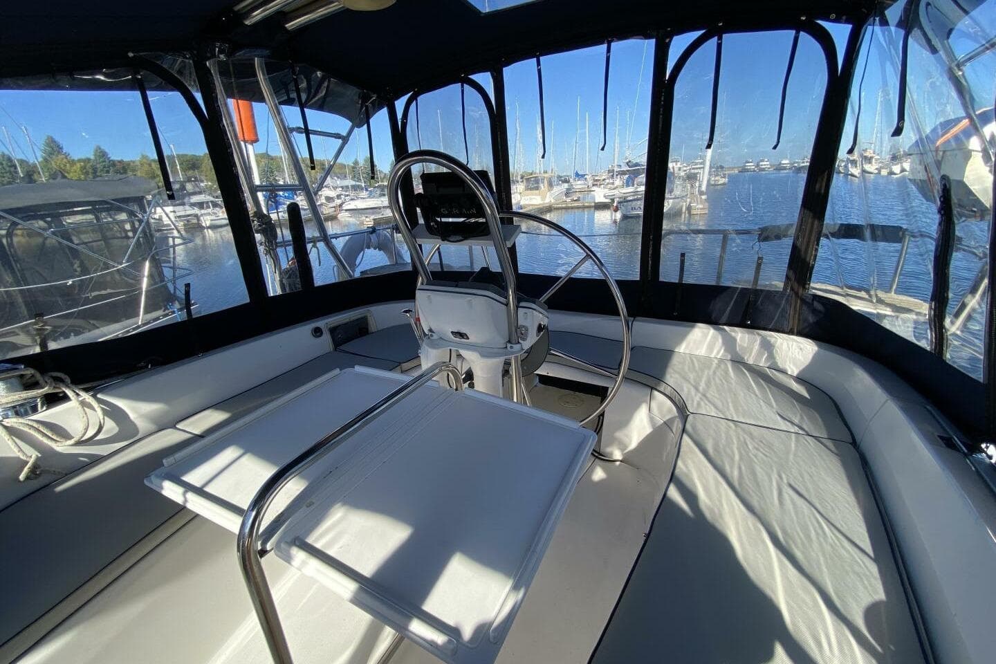 Interior view of a 2003 Hunter 356 sailboat cockpit with marina background.