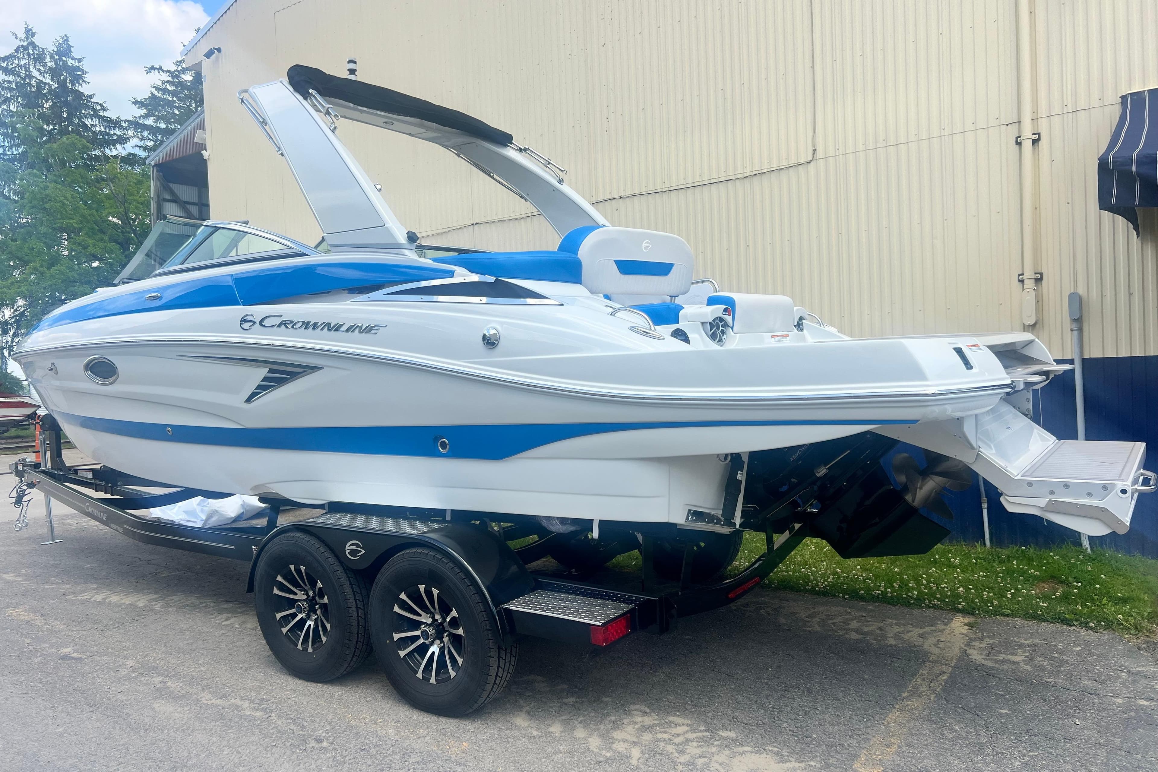 2027 Crownline 278 SS boat on trailer, blue and white design, parked outdoors.