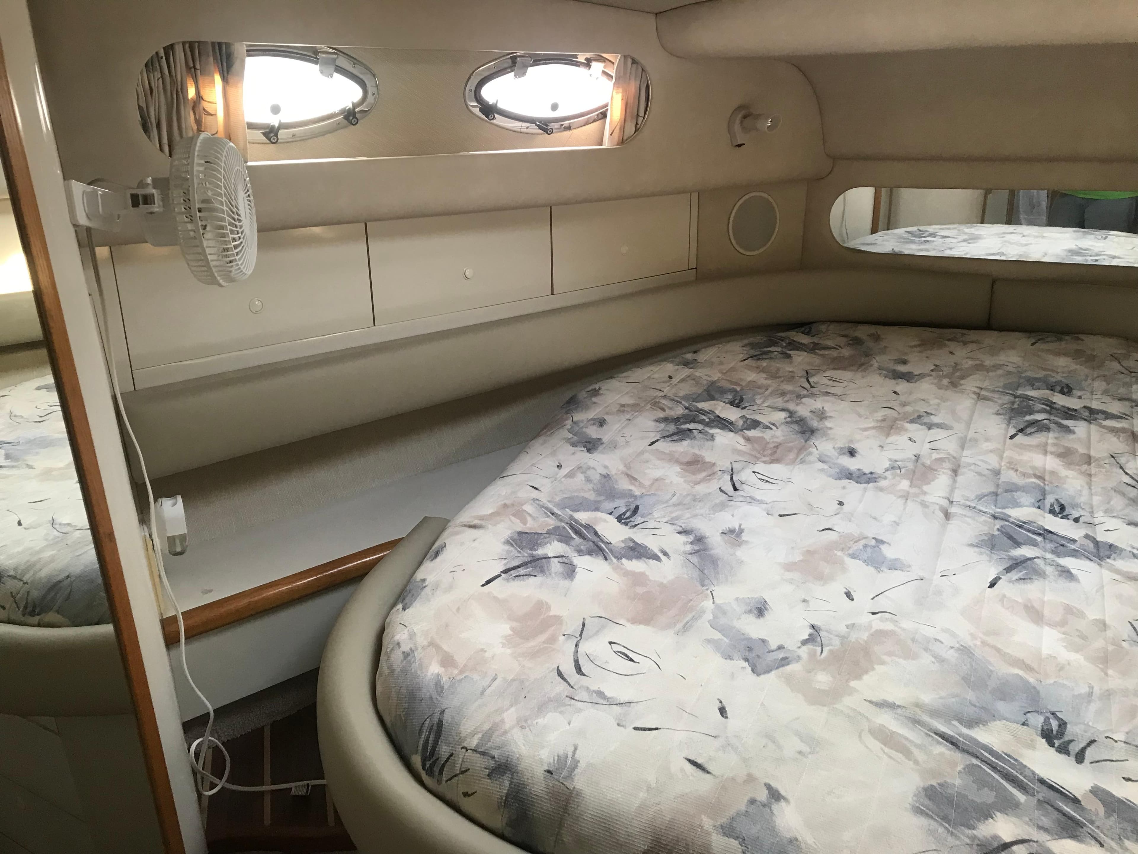 Interior cabin of 1995 Sea Ray 450 Sundancer with bed and porthole windows.