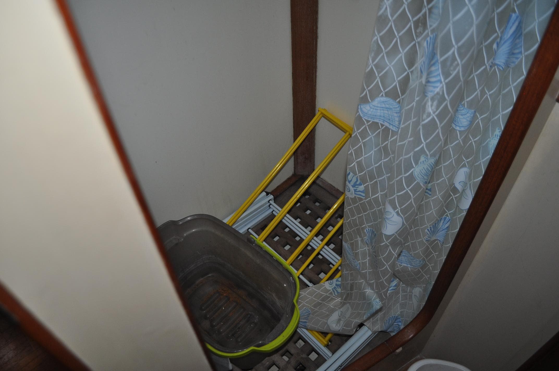 Shower area in 1983 Grand Banks 42 Classic boat with curtain and cleaning supplies.