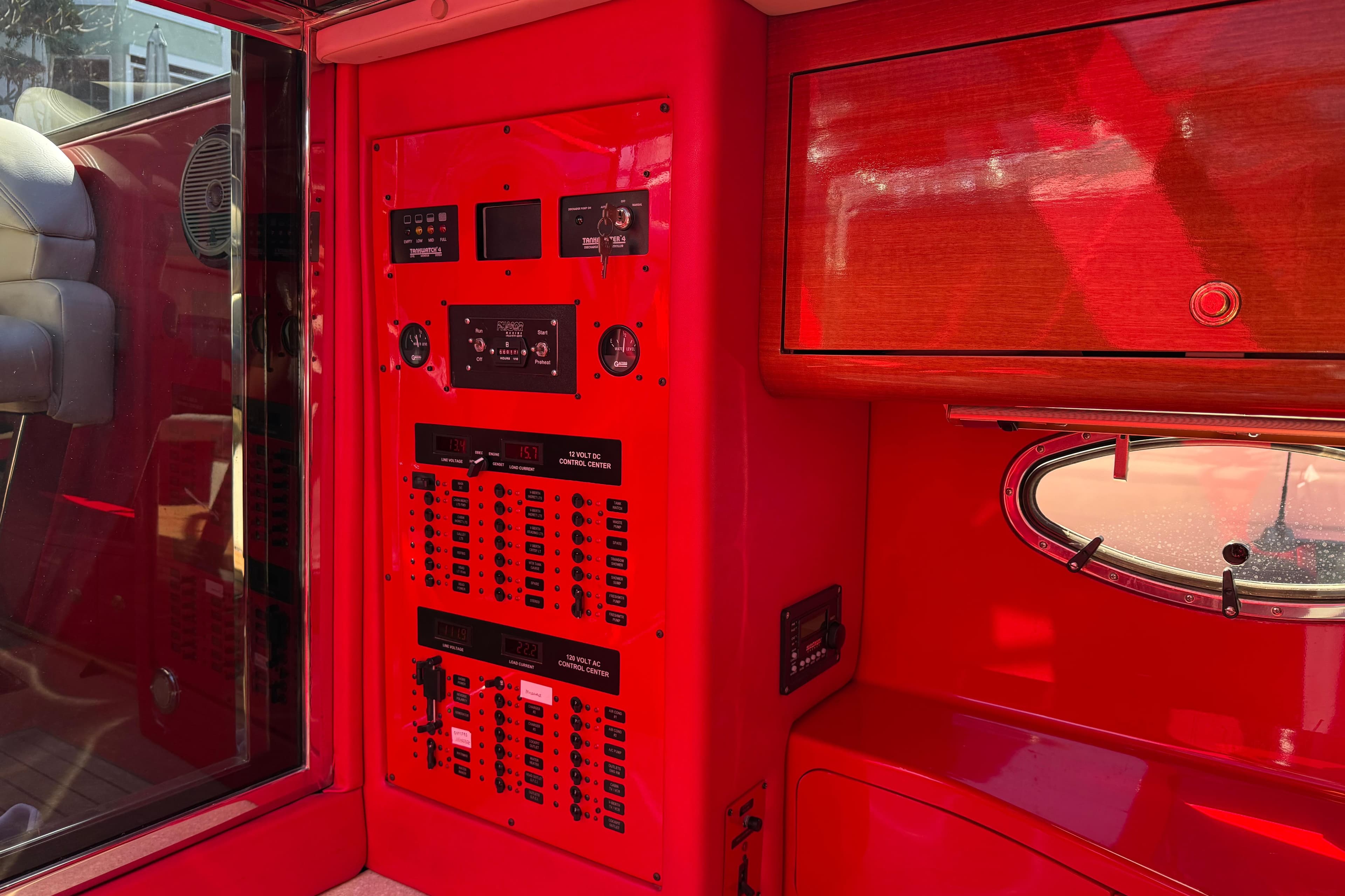 Red interior of a 2002 Hallett Custom High Performance Express Cruiser with control panels.