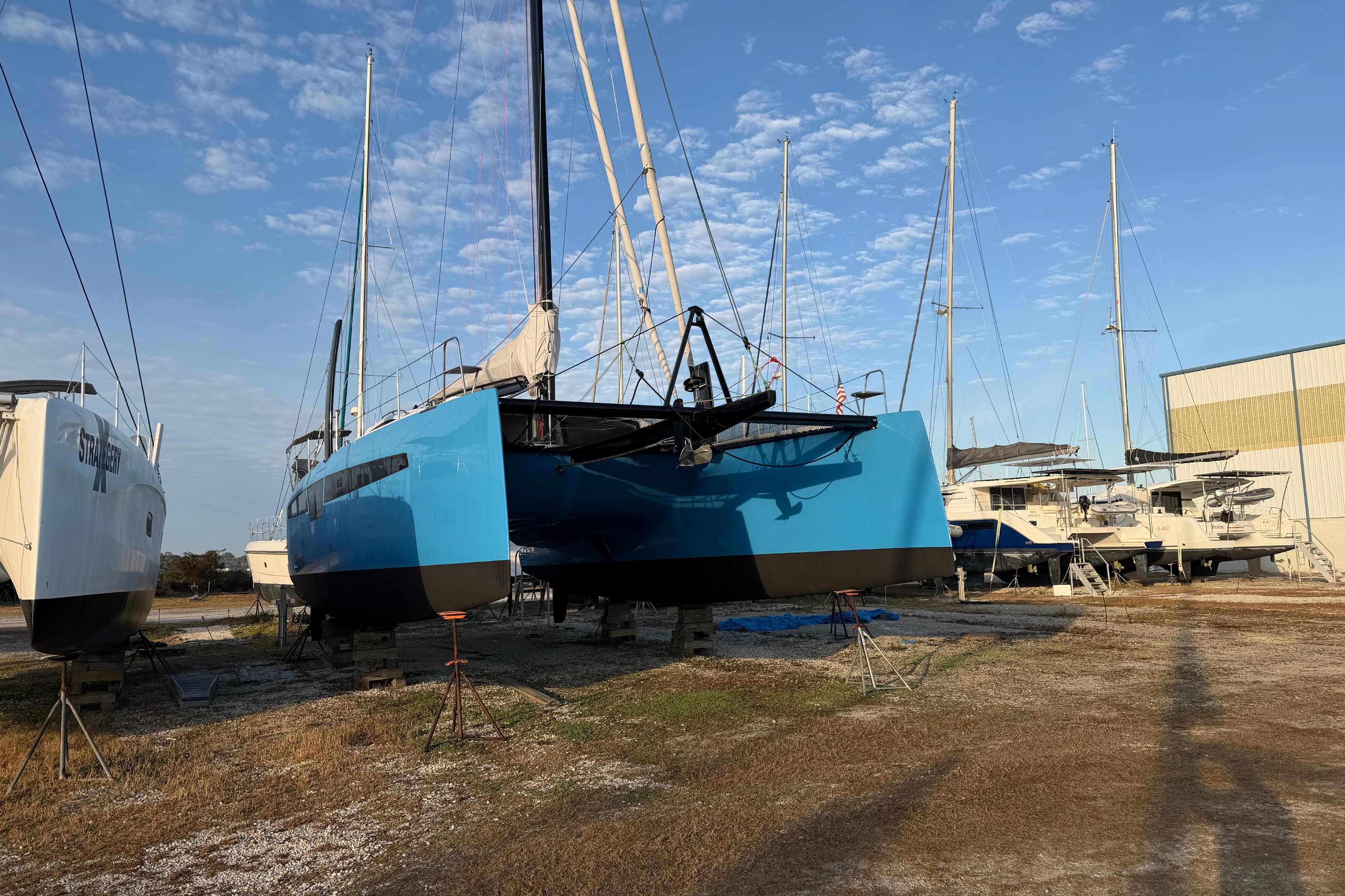 2025 C-Catamarans 48 in dry dock, surrounded by other boats under a clear sky.