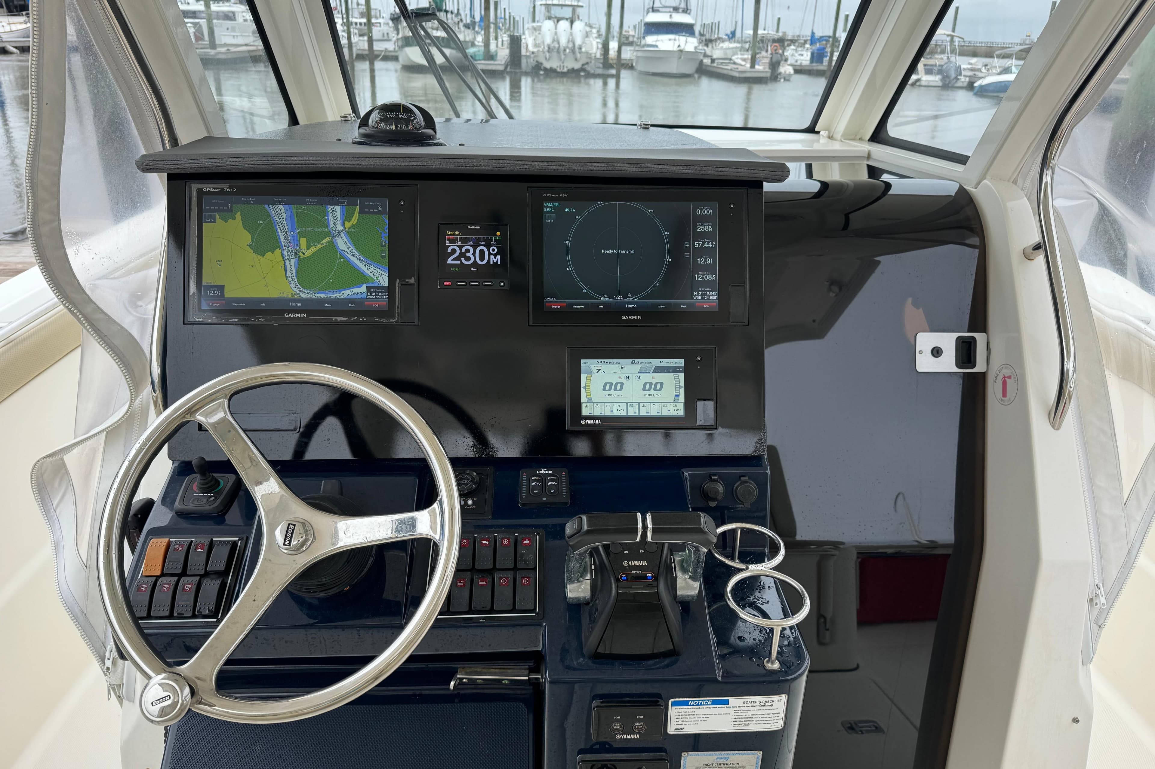 2018 Pursuit S 328 Sport boat cockpit with navigation screens and steering wheel.
