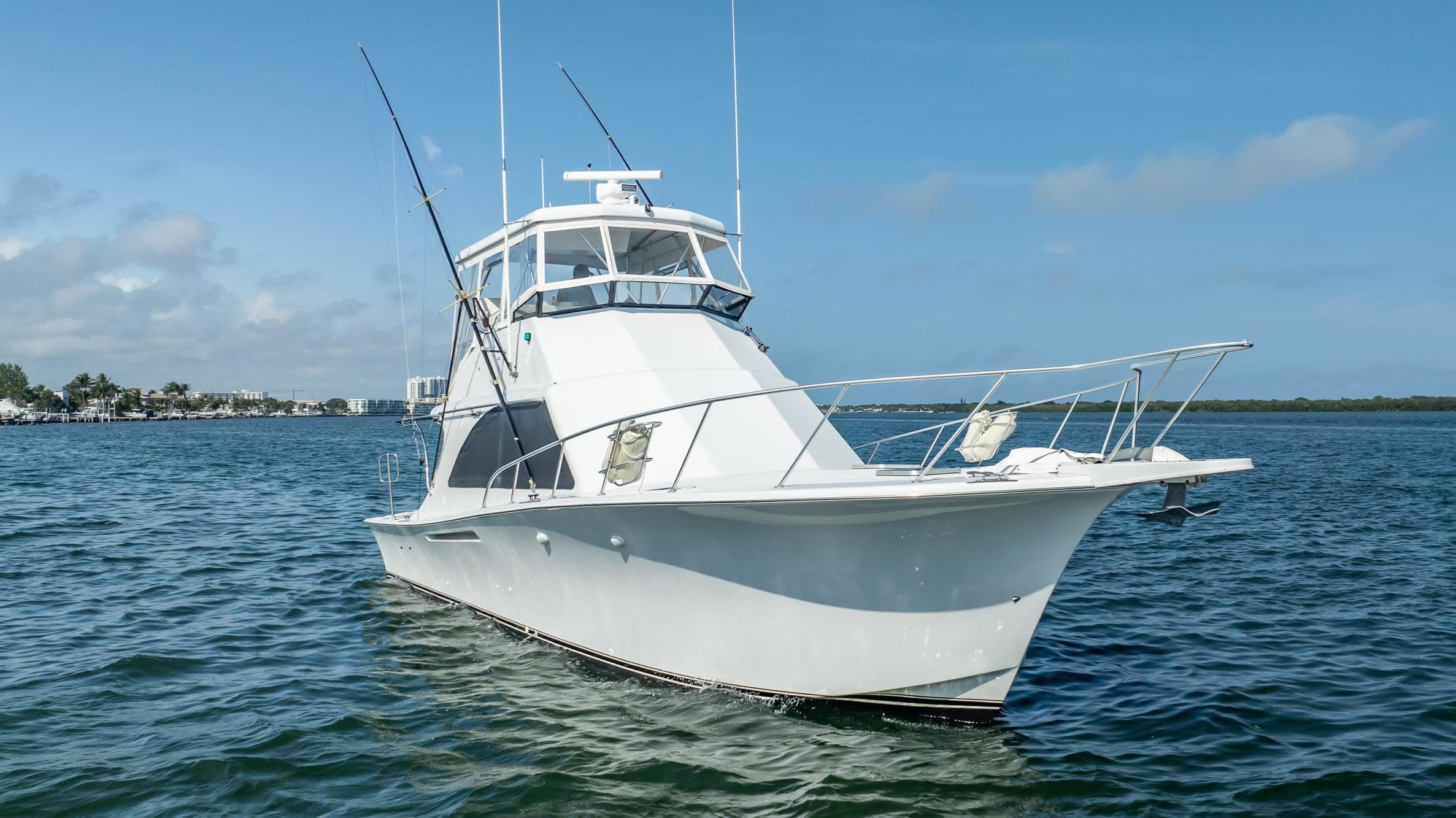 1991 Jersey 42 Convertible Sportfisherman boat on calm water under blue sky.