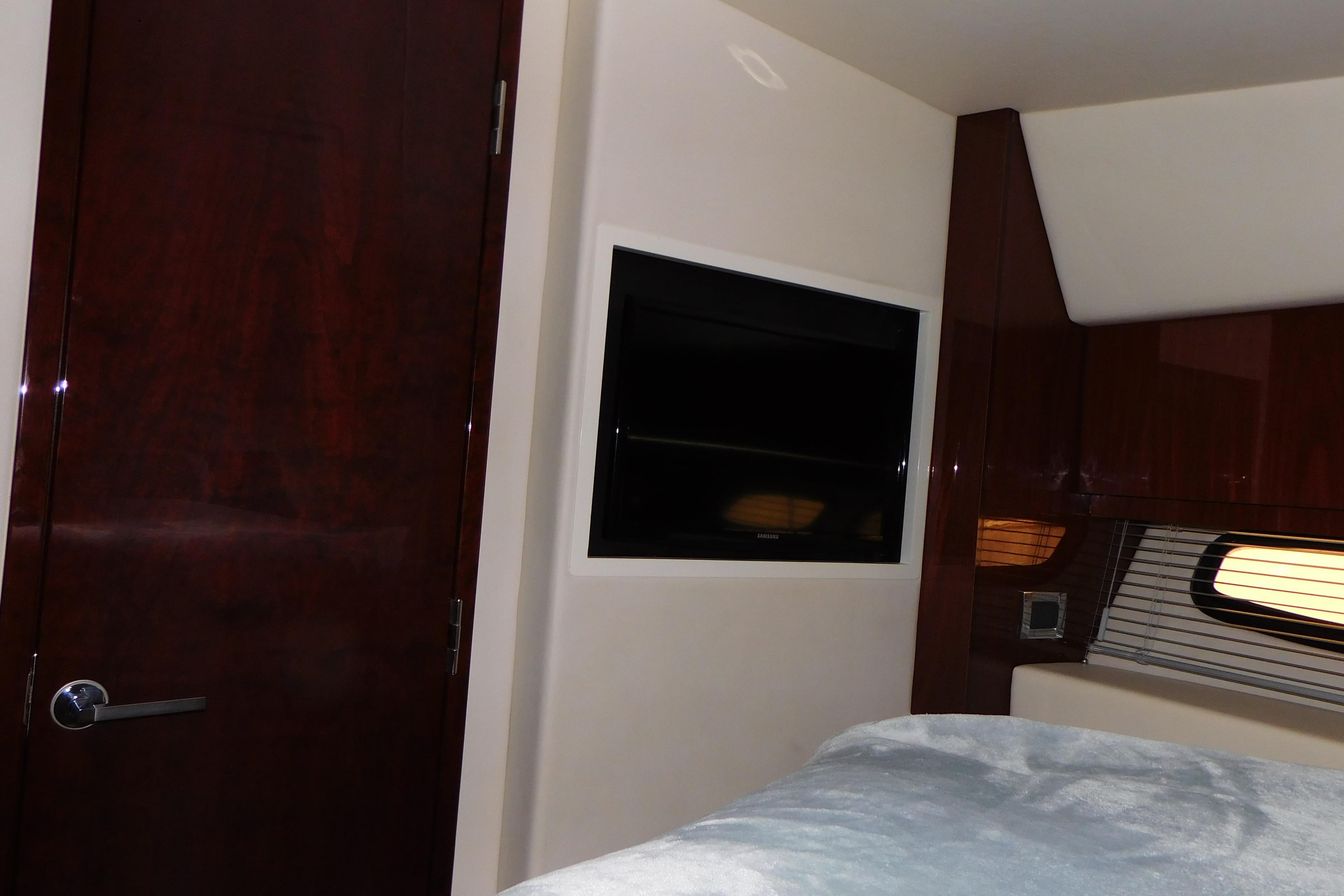 Interior of 2013 Sea Ray 510 Sundancer with TV, wooden door, and window blinds.