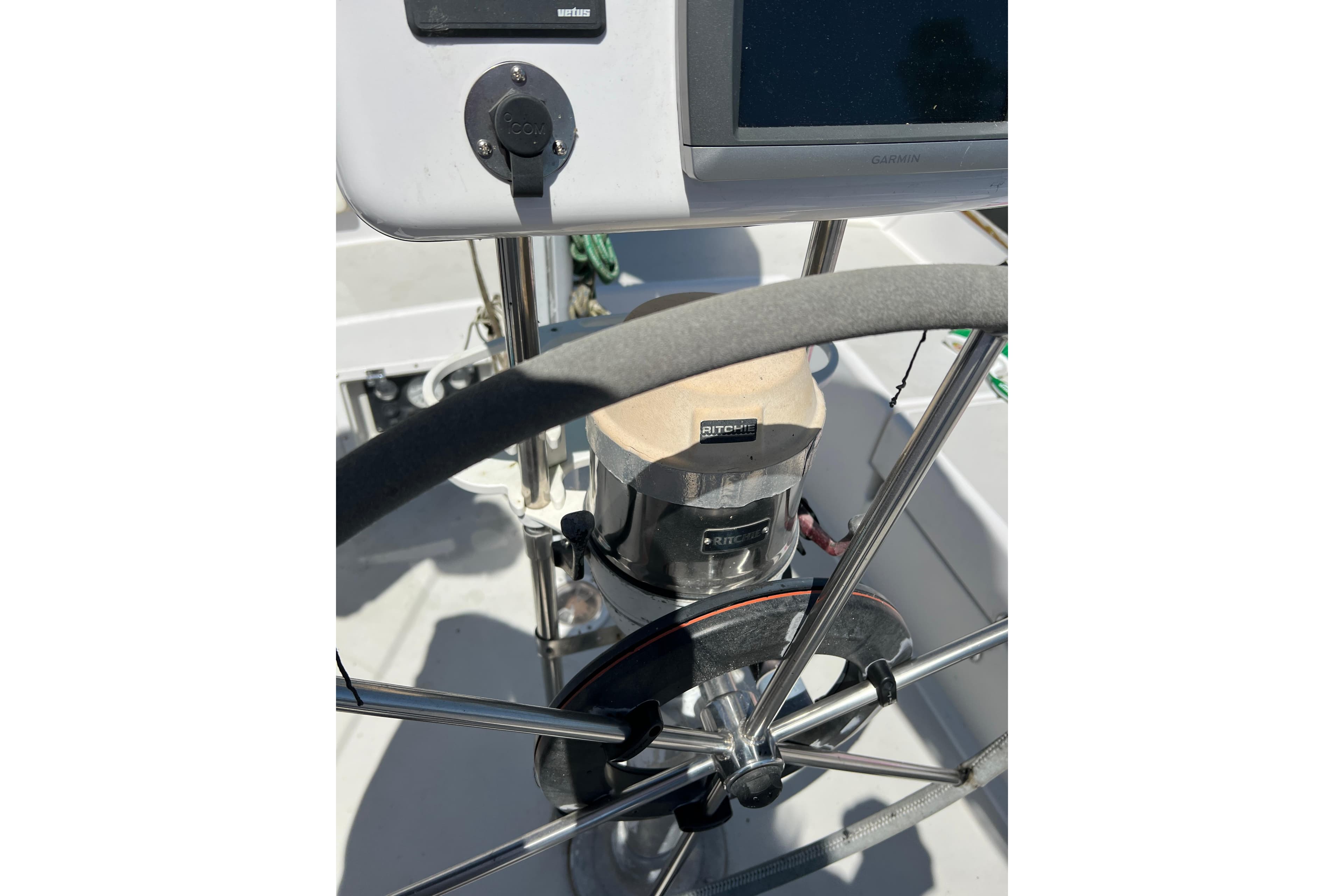 Steering wheel and compass on a 1979 Pearson 424 sailboat cockpit.