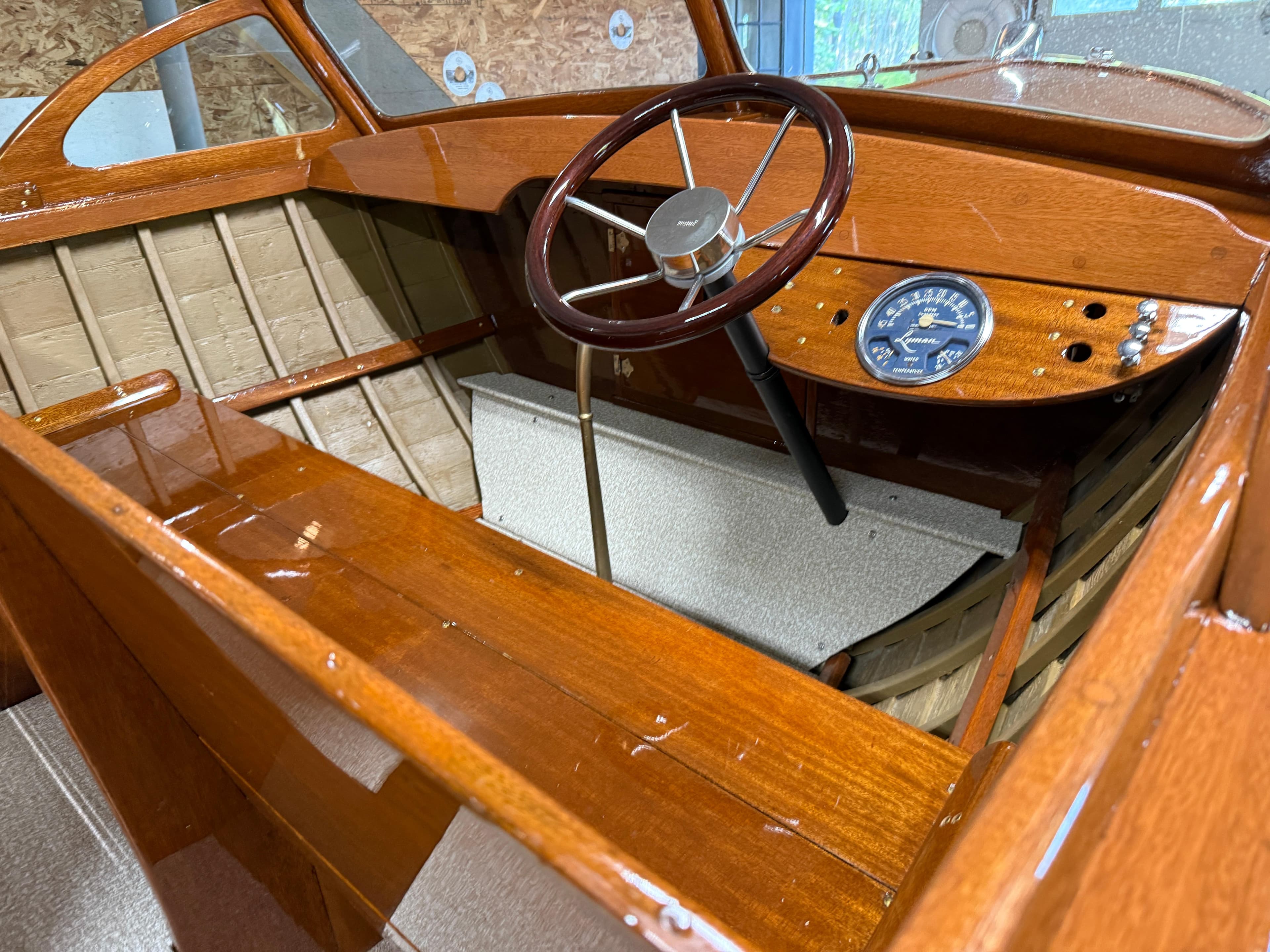 1955 Lyman 18 Inboard boat interior with wooden dashboard and steering wheel.