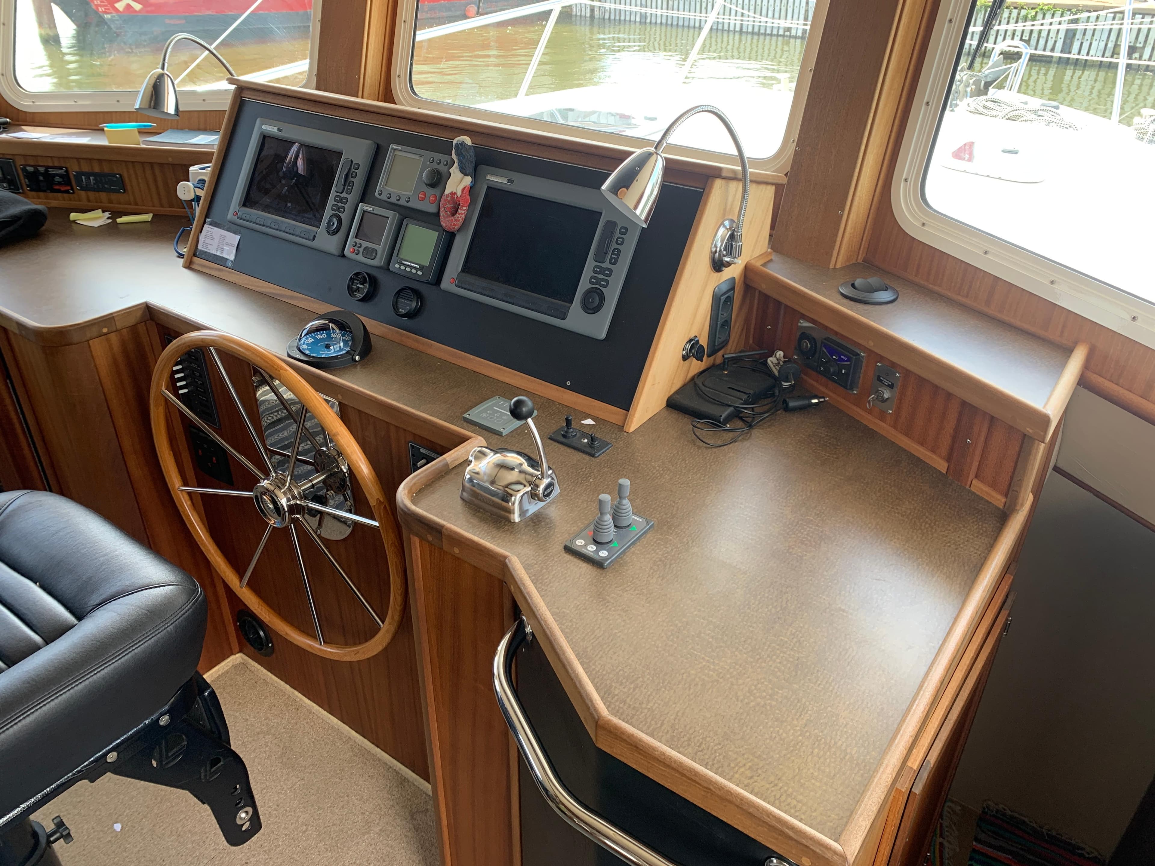 Pilot area of a 2010 American Tug 41, featuring navigation controls and steering wheel.