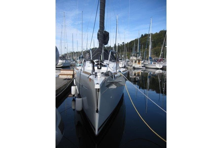 2022 Jeanneau Sun Odyssey 349 sailboat docked in a marina, surrounded by other boats.